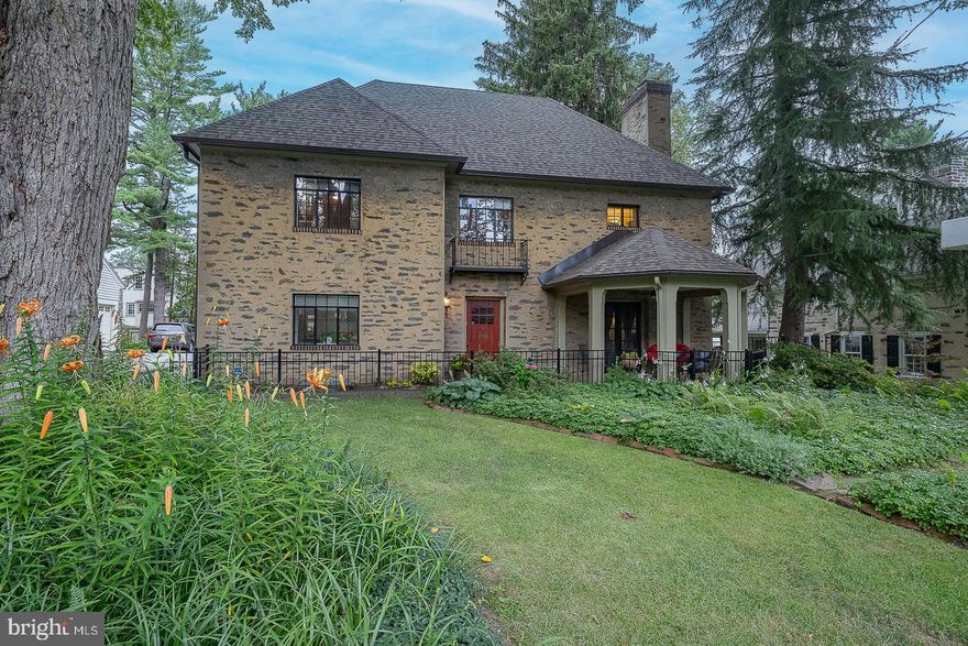 Charming, 5 bedroom, 3 and a half bathroom, Stone Colonial in a Walk-to-Everything Ardmore Location!  This stunning 3,315 sq ft home is nestled on a quiet, tree-lined street in the heart of Ardmore. Beautiful landscaping and a covered front porch create an inviting first impression. Inside, the thoughtfully updated layout blends timeless charm with modern comfort. Sliding doors open to the formal living room with a quintessential wood-burning fireplace and French doors to the cozy front porch create a warm and welcoming ambiance. The open dining area, perfect for entertaining, flows seamlessly into the updated chef’s kitchen, featuring a large center island, quartz countertops, stainless steel appliances, tile backsplash, and abundant cabinetry.  Off the kitchen are a convenient half bathroom and a versatile mudroom/laundry area with a large built-in pet bath, pantry cabinets, and access to the driveway and backyard.  Ascend the unique Craftsman-style staircase adorned with stunning stained glass panes to the second floor, boasting a spacious primary suite with crown molding, dual closets, and an ensuite bathroom with a granite-top double vanity and walk-in tile shower with a granite bench. Two additional bedrooms share a Jack and Jill bathroom with a tub, and a fourth bedroom and rear staircase complete the level. The third floor offers a fifth bedroom, a full bath with a clawfoot tub, and a large attic area with ample storage space.  The large lower level provides even more storage, two utility sinks, and a flexible workshop or art studio space.  Don’t miss the fenced-in backyard offering a tranquil retreat for dining al fresco or relaxing in the hot tub after a long day, or the coveted oversized two-car garage complete with a workspace and electric vehicle charging hookup.  Updates include a new roof (2023), new electrical panel and wiring (2023), and newer kitchen appliances.  Located in the highly regarded Lower Merion School District, this home offers unmatched convenience—just a short walk to the R5 train, local parks, Whole Foods, and the shops and restaurants of Wynnewood, Ardmore, and Suburban Square. This is a rare opportunity to own a home that perfectly blends classic architecture with modern amenities in one of the Main Line’s most sought-after neighborhoods.  This exceptional home—is a must-see!