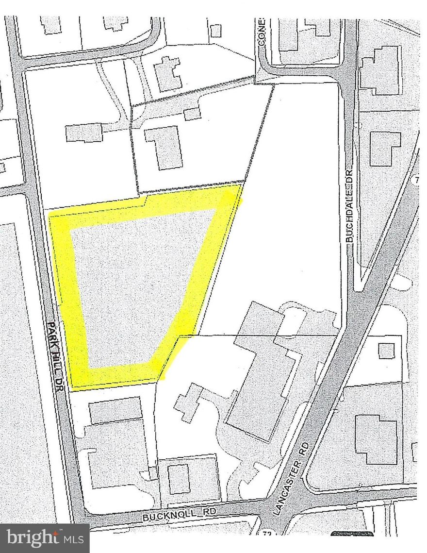 Stoned lot, currently used to park cars, fenced with chain link fence.