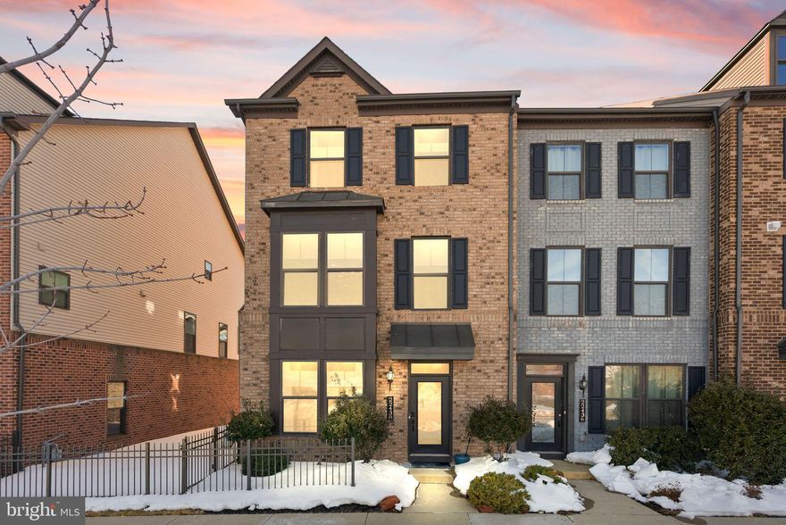 This stunning End Unit townhome in sought-after Westmoore, just moments from the Ashburn Metro, offers the perfect blend of space, style, and convenience. Featuring 4 bedrooms, 3.5 baths, a covered balcony, and a 2-car garage, this home is thoughtfully designed for modern living.

The entry level welcomes you with a tiled foyer and a private bedroom complete with a full en-suite bath featuring granite countertops and upgraded tile flooring—ideal for guests, an office, or multigenerational living. The garage includes overhead storage and a wall-mounted tool rack, along with additional storage tucked beneath the staircase in the utility room.

Upstairs, the main level showcases beautiful hardwood floors and an open, light-filled layout. The chef’s kitchen is a true showstopper, boasting an extended quartz waterfall island, quartz backsplash, classic white upgraded cabinetry, stainless steel appliances including a Wolf stove and hood, upgraded Café refrigerator, cooktop, and double wall ovens, Bosch dishwasher, Sharp under counter microwave, along with upgraded fixtures and a Nest smart thermostat.  The family room and dining room flank this modern center kitchen, while the covered balcony, complete with a gas fireplace and privacy shades, make it a cozy retreat in any season.  

The bedroom level features a spacious primary suite with a spa-inspired bath offering double granite vanities, a soaking tub, separate shower, and upgraded tile flooring. Two additional bedrooms share a well-appointed hall bath with granite counters, upgraded tile, lighting, and mirror. A conveniently located washer and dryer complete this level. An upgraded oak staircase with metal balusters adds architectural interest throughout the home.

Additional highlights include modern light fixtures including chandeliers and pendants, ceiling fans with lights, custom-fitted cellular shades on all levels, balcony shades, and Bluetooth ceiling speakers in the kitchen, living room, and balcony which add comfort and thoughtful upgrades throughout, a new water heater (2024), a 2-car garage with driveway, ample street parking directly in front.  Enjoy tranquil lake and pool views from the kitchen and dining area, with no homes directly across—offering exceptional privacy while being directly across from the community’s resort-style amenities, including the pool, fitness center, clubhouse, lake, and walking paths - and a prime location just steps from the 2 large parks, playgrounds, dog park, and amphitheatre.

Perfectly situated near the Ashburn Metro, Dulles Greenway, and Dulles International Airport, with easy access to shopping, dining, and entertainment at Broadlands Marketplace and Loudoun Station, this exceptional home offers both luxury and lifestyle in one unbeatable location!