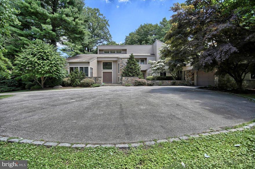 Welcome to one of the most unique and attractive neighbhoods in Lower Merion.  Springmont Circle and John Barry Drive quietly boast some of the most cleverly designed contemporaries: all well maintained and landscaped on generous lots.  Both streets are cul de sacs eliminating cut through and non-essential traffic.   A total of only 32 homes grace the greater community.  The featured home rests prominently on the corner of Springmont Circle and John Barry Drive on the slight crest of an acre plus lot.  Set back off the road it provided an opportunity to landscape the entire property providing an extremely attractive street view and a very private backyard featuring a heated pool and jacuzzi.  It is a pie shaped lot whose back yard is slightly sloping and wooded.
        The home built in 1980 has been lovingly maintained with numerous upgrades and floor plan changes to accommodate the family needs at the time.  For example, while there are 5 bedrooms, there was an au pair bedroom on the first floor with full bath.  When that no longer served the purpose, the room was reduced in size, the shower was removed, and a generous laundry room was created which still has a powder room and the slightly smaller bedroom.  All this could be reversed to add a full 6th bedroom.
The home has a combination of generous and functional spaces whose ceiling heights in half the home help define their personalities.  One enters the property on a slightly curved driveway.  The covered front double door is on the left,   2 car space driveway additional parking on the right and an oversized 2 car garage ahead.  The top of the driveway features a large circulalar space swhere one can completely turn around    The 3 traditional spaces offer generous views ofthe backyard and the pool. All spaces enjoying great light.  Both the generously sized Living Room and Family Room include a fireplace; the latter featuring a floor to ceiling stone front.  The kitchen is a large rectangle whose center holds a granite top center aisle and is designed to make all the appliances easy to access.  A special feature is an eat in space aside large and bright windows.

We look forward to seeing you.