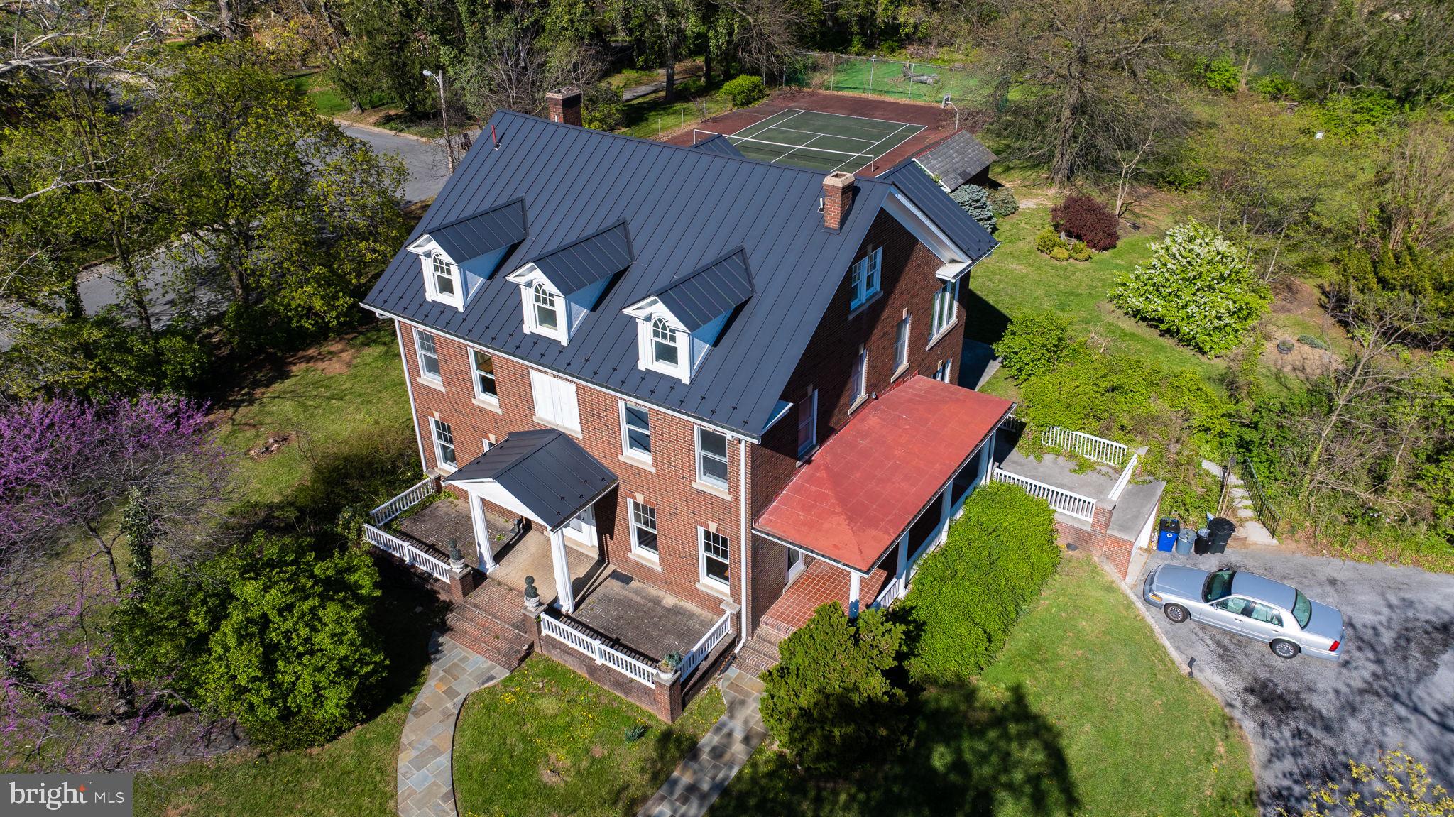 MAJESTY COLONIAL LOCATED ON OVER 2 + ACRE OF PROPERTY OVERLOOKING THE WEST END OF MARTINSBURG AND BORDERING THE WEST SIDE OF CITY -OWNED LAKE THOMAS. HOME BOASTS THREE SPACIOUS PORCHES. TWO-STORY BACK PORCHES OVERLOOKING THE LAKE AND FEATURING DRAPES FOR PRIVACY ,AS WELL AS PROTECTION FROM SUN AND RAIN. PROPERTY INCLUDES LARGE CLASSIC TENNIS COURT READY FOR YOUR PERSONAL TOUCH AND UPGRADES TO MAKE IT YOUR OWN . HOME BUILT APPROXIMATELY 1923 AND IS SOLD AS IS AND AS SEEN BUT HAS BEEN WELL TAKEN CARE OF. HOME FEATURES 6 BEDROOMS AND TWO FULL BATHROOMS PLUS A POWER ROOM , HARD WOOD FLOOR JUST REFINISHED ENHANCING THE HOME'S TIMELESS APPEAL AND CHARM ,AND GREETING FOYER AND LUXURIOUSLY LARGE LIVING ROOM CONNECTING TO SUNNY OFFICE THAT OVERLOOK GORGEOUS BACK YARD. RECENTLY INSTALLED PAVED WALKWAY . HOME INCLUDEES SPACIOUS KITCHEN WITH BAR AND
DINNING AREA WITH TIN CEILING ADDITIONAL BAR IN BASEMENT ,AS WELL AS A FORMAL DINNING ROOM WITH FRENCH DOORS PERFECT FO ENTERTAINING. HEAT PUMPS WITH GAS FURNACE BACK-UP - ZONED . LAUNDRY ROOM CONVENIENTLY LOCATED UPSTAIRS FEATURING BUILT-IN SHELVING. ATTIC IS FINISHED INTO 2 OF THE 6 BEDROOMS WITH AMPLE STORAGE
SPACE AND A CEDAR CLOSET. SELLER HAS ADDED A STATE-OF-THE -ART STANDING -SEAM METAL ROOF , KNOWN TO LAST A LONG TIME -MANY UPGRADES MADE THROUGHOUT THE INSIDE OF HOME AS WELL **PLUS EASY TO VIEW CALL YOUR AGENT**