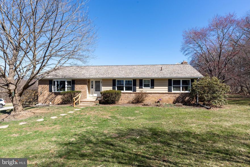 Welcome to this charming, original-owner home, nestled on a sprawling 8.2 acre lot that offers privacy and natural beauty. This property borders a small stream and features wooded surroundings, with your own forest of Red Buds and Dogwoods bordering expansive back and side lawns. The spacious living space offers a comfortable layout with a large living room, highlighted by a bay window that provides natural light and a perfect viewing spot for the many bird species that call this property home. The expansive eat-in kitchen offers a near-new stainless dishwasher and an Anderson slider with built-in blinds that opens to a recently renovated deck.  A formal dining room provides an additional space to entertain guests. All 3 bedrooms enjoy generously sized closets. The primary bedroom has its own ensuite bath as well as access to a large 3-season room with a cathedral ceiling and a woodstove. This 3-season room also has access to the deck. A hall bath and a large linen closet (that could make a perfect laundry closet) complete the main level of this home. The lower level features a large brick fireplace that would be the perfect centerpiece for a family or rec room (walls and ceiling are already in place). A slider provides access to the backyard and a half bath and laundry/mechanicals room round out the lower level.  This level also provides access to the oversized 2-car garage with tons of space for extra storage. Outside, you'll find an almost new fence surrounding a cement in-ground pool. The expensive yard provides plenty of space for play and entertaining, but it doesn't stop there - this property extends well beyond the tree line (to the stream) for a total of 8.2 acres! The property is currently in the voluntary CRAC Forest Conservation Program which provides agricultural tax benefits+. With numerous recent updates (roof 2+ yrs), HWH (Nov 2024), dishwasher (2+ yrs), Pella slider (2+ yrs), deck reno (2+ yrs), septic pumped (Nov 2024), this beautiful property is move-in ready but offers room for you to update and personalize however you'd like. With Spring just around the corner and the hundreds of flowering trees about to bloom - don't miss this opportunity to own your own piece of Carroll County's  countryside.