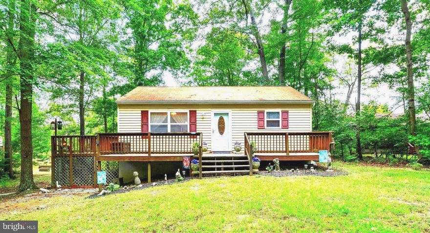 Step into this Charming, Cozy waterfront Cottage with its own private pier with water access. The home features 2 bedrooms with water views and 1 full bath with an open kitchen and living room combo. Recent updates include new paint, carpet and hardwood flooring in the kitchen. The bathroom has also been updated with a new vanity and ceramic tile flooring. The unfinished basement has a washer and dryer and space for loads of storage. Step outside and relax on the 2 decks located on both the front and side of the home. This property is located in a highly desired neighborhood. The golf cart-friendly Bay Quarter Shores Community residents enjoy access to a variety of amenities, including a community beach, pool, clubhouse, boat ramp, pier, picnic area and playground, tennis courts & more! Looking for peace and tranquility, this home is it! Home is move-in ready.