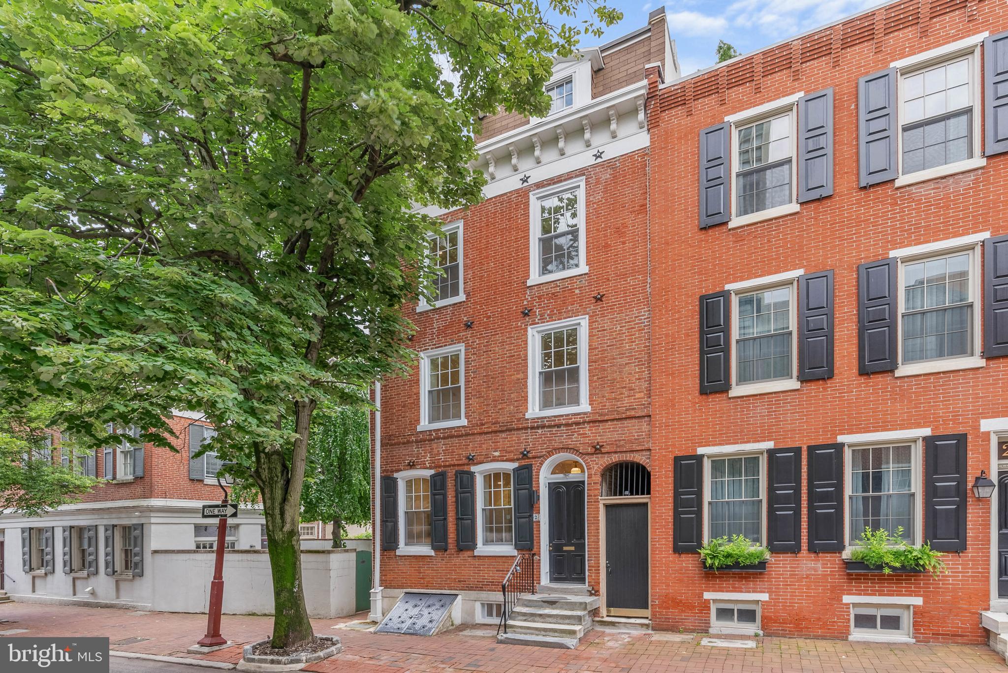 On offer is a rare chance to own a meticulously renovated luxury residence in the heart of Philly's sought-after Society Hill neighborhood. This large, 4-story home boasts 4 bedroom suites totaling 4 full and 3 half bathrooms, a finished basement, multiple outdoor spaces, a bonus kitchenette, dual-zone HVAC, distinctive details throughout, and placement in the top-rated McCall School catchment. A historic block lined with mature trees and a brick sidewalk leads to 202 Spruce St's towering red brick facade. Inside, a vestibule ushers you into the open, bright, and airy main level, framed by hardwood floors and soaring ceilings. A pair of windows at the front illuminates the living room, where there's plenty of space for hosting guests. At the center is a gleaming, all-white gourmet kitchen fitted with custom shaker cabinetry, waterfall counters, high-end stainless steel appliances, brass fixtures, and a massive island with seating. A powder room sits by the staircase. Completing this level is a sun-soaked dining room showcasing dramatic 2-story ceilings and a wall of windows. Sliding doors open to the secluded patio, making indoor/outdoor entertaining a breeze. This peaceful space can be transformed into a private oasis perfect for relaxing away from the city's hustle. More living space, along with another powder room, is found in the expansive finished basement, ideal for a family room, gym, or hobbies. On the home's second level, there's a study area off the staircase that overlooks the dining room. Past one of two laundry closets, a hallway leads to the bright, spacious primary suite that features tall windows, two bespoke closets, a bonus flex space that could act as a dressing area, and a hotel-like bathroom adorned with a double vanity, linen cabinets, and a glass-enclosed rainfall shower. Up on the third level, a kitchenette and a powder room are by the stairs. A shady terrace off the rear is another outdoor spot where you can hang on good weather days. A second, large bedroom suite completes this level. Topping off the home are two more bedroom suites, an additional laundry closet, and a pair of balconies. 202 Spruce St's utilities include central a/c, gas heat, and electric hot water. This property also includes a 10 year tax abatement! In addition to everything inside, this fantastic location earns a Walk Score of 94! Top restaurants, friendly shops, popular markets, and lively entertainment fill the surrounding blocks. Nearby, Penn's Landing hosts holiday events and Spruce Street Harbor Park along the riverfront is a go-to destination all spring and summer. Neighboring Old City has lots to explore, plus idyllic Washington Sq Park, Pennsylvania & Jefferson Hospitals, and Center City are all within walking distance. There's also easy access to Columbus Blvd, I-95, I-676, and South Jersey. Schedule your tour today! Square footage amount includes finished lower level.