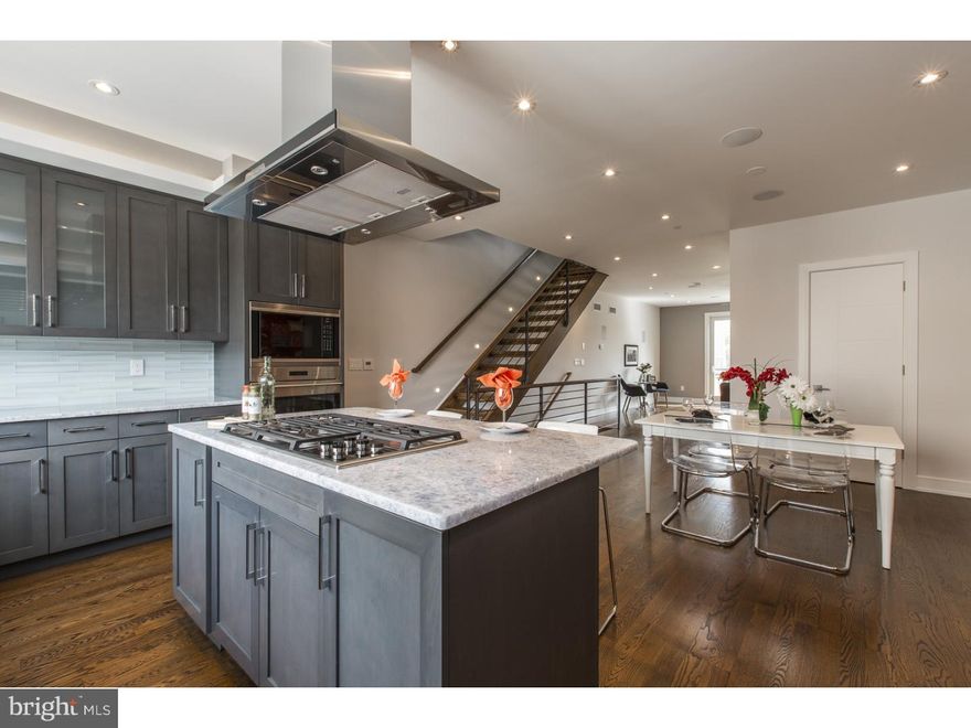 Luxury, MODEL home featured at Shot Tower Estates; a new construction townhome with an ELEVATOR and 2 car parking in Queen Village. With over $35K worth of upgrades and available for a quick settlement, this home features 4 Bedrooms, 4.5 Baths with 4,300 sq. ft. in a gated community.  Located in the rear of the development,  enter into the first floor which offers a Garage and a full Bedroom suite (ideal as a guest suite or home office) with access to the private back patio.  Downstairs, the finished Basement makes for a perfect Media room, Gym or guest suite with its exceptionally high ceilings, a full Bathroom and custom built wet bar with wine frig.  Upstairs, the open floor plan was designed with entertaining in mind with a surround sound system throughout, a Living Room with Juliet balcony overlooking the historic Shot Tower and its main focal point being a stunning gas fireplace with a tile surround, stone mantle, custom cabinetry and floating shelves on either side.  The professionally designed Chef's Kitchen showcases custom-built cabinetry, an island with bar seating, upgraded translucent quartzite counters that are lit from underneath, a Wolf/Subzero appliance suite with cooktop, stainless floating hood, wall oven, microwave and also features cove & under cabinet accent lighting and a beautiful glass backsplash. The Dining area sits alongside the Kitchen as well as a Powder room; ideal for hosting dinner parties!  The 3rd Floor features 2 large Bedrooms, a full Bath and Laundry room with a sink, folding table and upper cabinetry.  4th floor Master Suite is pure luxury with its Bedroom with tiled gas fireplace, dual walk-in closets and a Spa-like Master Bath with huge shower with multiple shower heads, freestanding soaking tub, heated floors, and a custom double vanity. Fireworks and sunsets can be seen from the huge roof deck with outdoor audio and 360 views of the city! Elevator stops on every single floor. Whole House audio in every living space, 2 alarm key pads, video intercom system and LED lighting throughout are just some of the intricate smart home features that are offered.  Oak, stained in place hardwood floors, ample closet space, ceiling fans and huge windows for natural lighting add to this custom mini mansion in the heart of Queen Village. Walking distance from many restaurants, bars, cafes and the Delaware River Waterfront. 10 yr tax abatement pending.  Impressive, QUALITY built home; builder pays close attention to every detail!