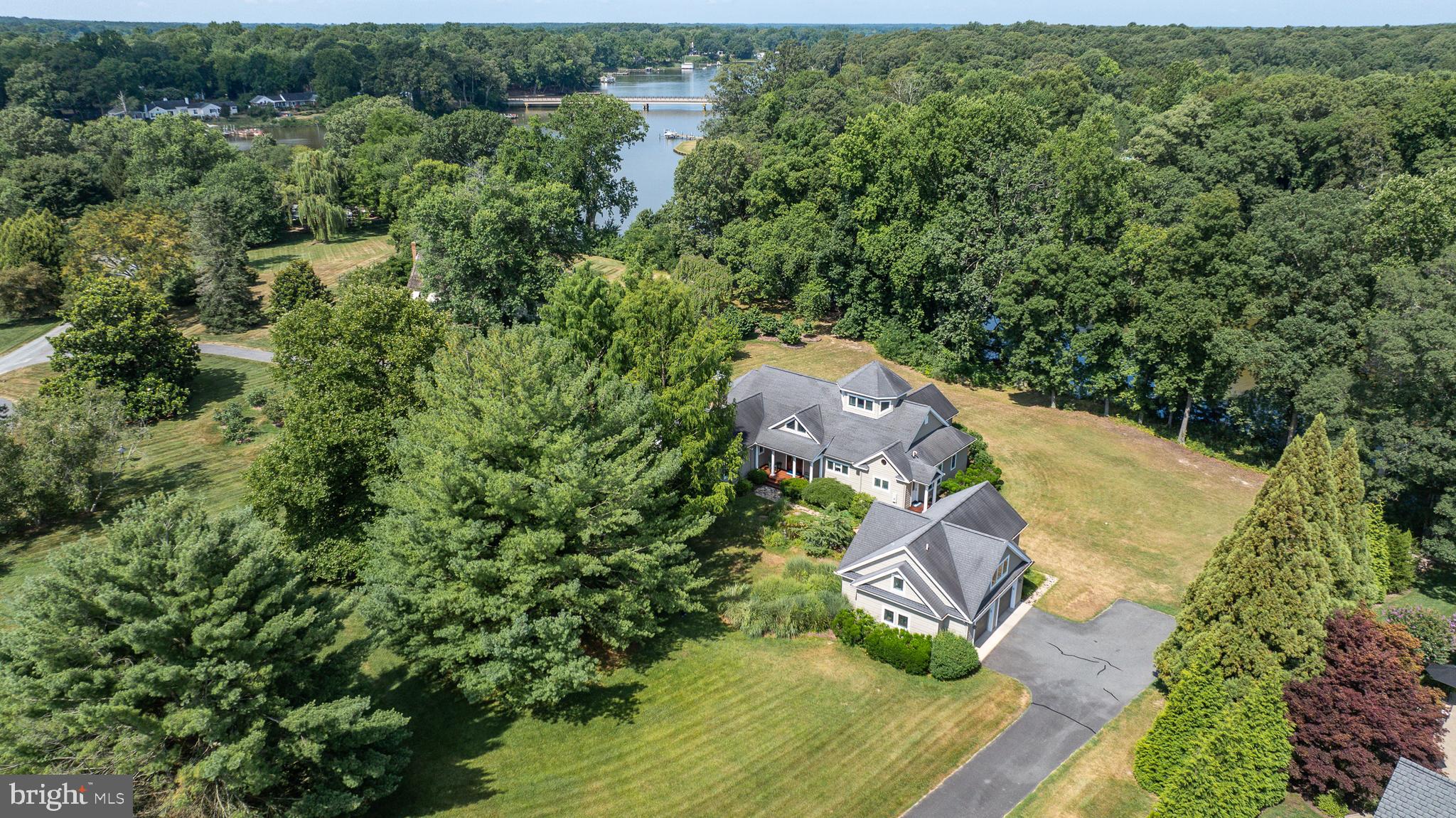Nestled in the highly sought-after Cookes Hope community, this waterfront retreat built by Willow Construction redefines upscale living. The main house, featuring 3 bedrooms and 2.5 bathrooms, includes a desirable main-level primary suite with a custom walk-in closet, double vanity, soaking tub, and tiled steam shower—all with enchanting water views. The welcoming den, adorned with a gas fireplace, serves as a perfect escape or home office space. The birds-eye lookout loft room bathes in ambient light, and the kitchen boasts a breakfast bar, warming drawer, and beverage refrigerator. Enjoy hosting gatherings on the screened-in porch or waterside deck with a natural gas hook-up for grilling. A detached guest apartment, complete with 1 bedroom and 1 bathroom, provides additional flexibility and comfort. Additional amenities include a detached 2-car garage, built-in bookcases, cathedral and vaulted ceilings, and a covered front porch. Situated on 1.9+/- acre property and also includes a 2024 slip rental at the community pier.