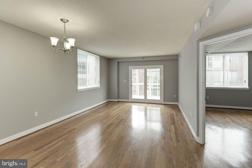 LOCATION! LOCATION! Stunning 2BR/2BA condo located in the heart of Arlington.  Almost 900SF of beautiful hardwood floors, fresh paint, and FLOODED with natural sunlight. Corner unit gives maximum windows throughout. ENORMOUS enclosed sunroom with WALLS OF GLASS and gorgeous urban views! Kitchen has white cabinets, granite counters, newer appliances, brand new washer/dryer...METRO/GARAGE SPACE/MORE