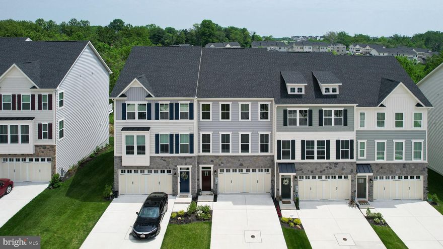 Modern and well-maintained, this 3-bedroom, 3.5-bath townhome in the sought-after Magness Mill community offers three finished levels, a 2-car garage, and over 2,000 square feet of living space. Built in 2019, it features a Colonial-style design with timeless curb appeal and a private driveway. The entry level includes a large flex space with a full bath—perfect for a guest suite, home office, or rec room—with direct access from the built-in garage and concrete driveway. On the main level, enjoy an open-concept layout with hardwood floors, recessed lighting, and excellent natural light. The gourmet kitchen boasts white cabinetry, granite countertops, stainless steel appliances including a double oven, a large island, and a walk-in pantry. A built-in desk nook, half bath, and spacious living and dining areas offer both comfort and versatility. Step outside to the oversized deck—ideal for outdoor dining or entertaining. Upstairs, you'll find three bedrooms, two full baths, and a laundry area. The large primary suite includes a walk-in closet and upgraded en-suite bath with dual showerheads and a built-in bench. Backing to trees for added privacy, this home is close to walking trails, shops, restaurants, and major commuter routes.