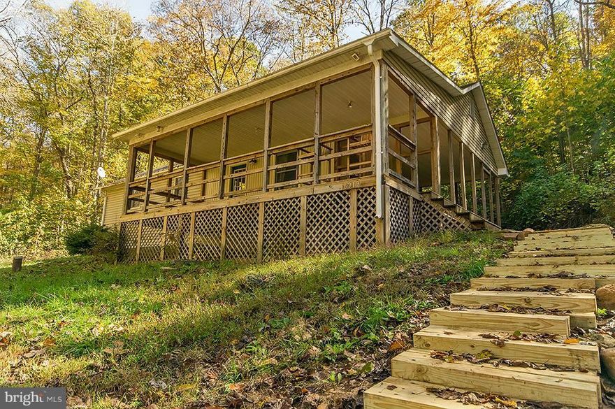 3BR, 1BA rancher w/  wood floors, flue for wood stove, open LR+dining+kitchen. 2 lots totaling 2.4+/-  AC w/ 253' waterfront on the Cacapon River. Enjoy the river view from the wraparound covered deck or relaxing by the fire pit on the river bank. Recent flood elevation showing cabin is out of flood plain. Seller paid Home warranty. Bring your canoe, kayak,tubes & fishing poles for weekend fun!