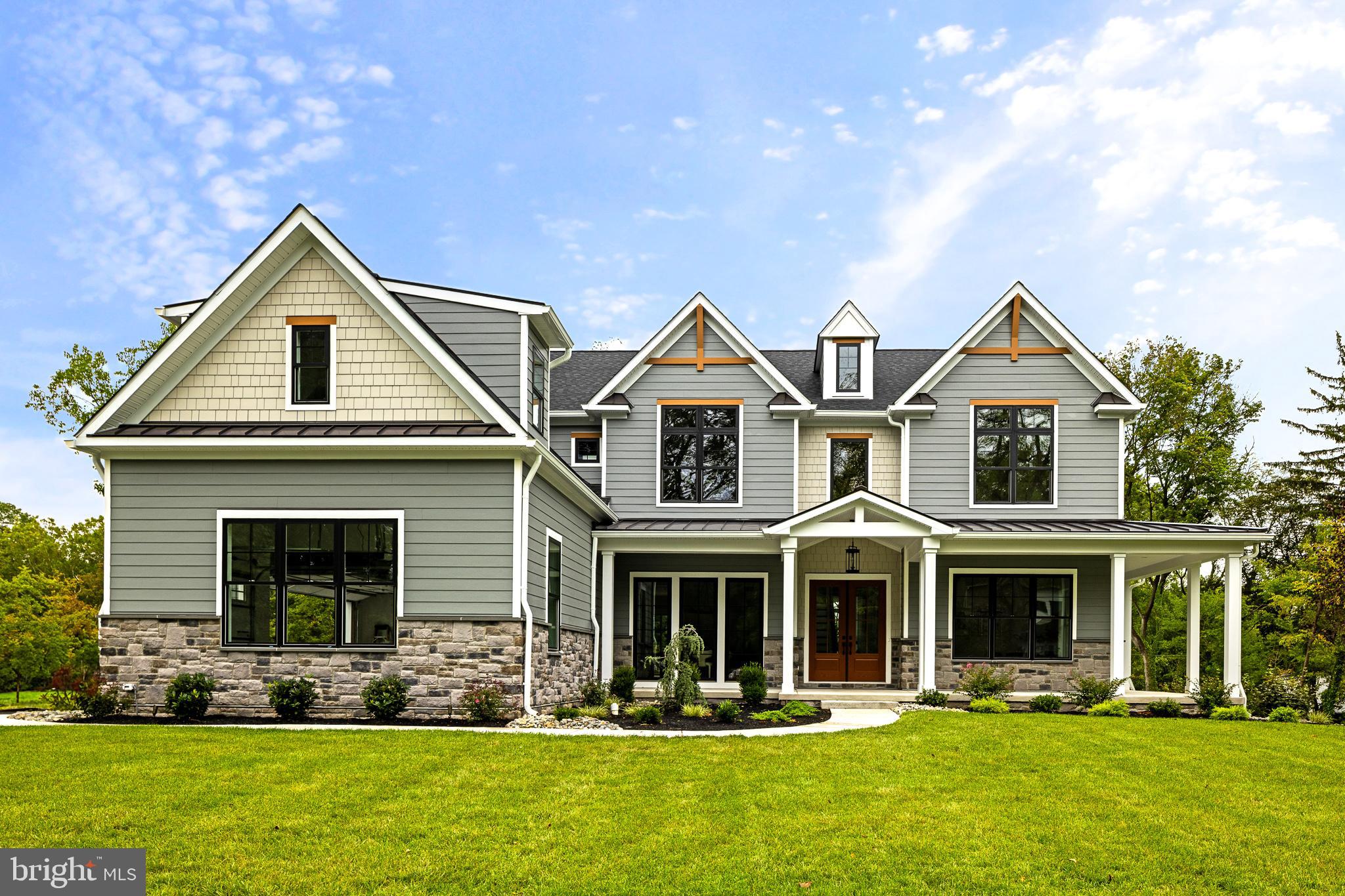 The Gwynedd Reserve is an intimate, boutique enclave of just five bespoke semi-custom residences, gracefully situated on a tranquil cul-de-sac in coveted Lower Gwynedd Township. These distinguished modern farmhouse-style residences offer a refined architectural sensibility, thoughtfully juxtaposed against the bucolic charm of their pastoral surroundings. A collaboration between the esteemed Mark Salamone Homes and Design Pro Development, this exclusive collection embodies a rare synthesis of craftsmanship, setting, and sophistication. Not merely a model home—but the pinnacle of design and craftsmanship. Welcome to 770 Johns Lane, an extraordinary new construction residence nestled at the heat of The Gwynedd Reserve. From the moment you arrive, lush landscaping and impeccable curb appeal set the tone for what lies within. Step inside to a soaring two-story foyer adorned with intricate trim work, immediately showcasing the home’s artisanal quality. To your right, through glass French doors, sits a private study—perfect for work or quiet retreat. To your left, a formal dining room is anchored by floor-to-ceiling windows, bathing the space in natural light and sophistication. At the heart of the home lies the breathtaking great room, with character-grade white oak hardwood floors and a dramatic floor-to-ceiling El Dorado Casa Blanca stone fireplace. Expansive windows invite in serene views, blending indoor and outdoor living. The adjacent breakfast area and kitchen redefine modern culinary excellence. A grand island sits beneath designer lighting, flanked by two-tone cabinetry, natural quartzite countertops, and artisan subway tile backsplash. Top-tier appliances include a 48” Wolf range with infrared griddle and Sub-Zero refrigerator. Just beyond, you’ll discover the pièce de résistance for any serious entertainer: a full scullery, finished in a midnight green palette with under cabinet lighting and featuring a second suite of appliances. Tucked just beyond the kitchen lies a well-appointed mudroom, thoughtfully designed with custom built-ins for both function and style. Completing the main level is a spacious guest suite, featuring its own beautifully finished private bath—an ideal retreat for visitors. On the second level, pause to admire the sweeping overlook of the great room. The right wing hosts two bedrooms, including a front-facing suite with cathedral ceiling and exposed wood beam, joined by a beautifully appointed Jack-and-Jill bathroom with a double vanity and tub-shower combo. A princess suite offers another vaulted ceiling with beam detail and a serene en-suite bath. Across the hall, the laundry room is reimagined with ceramic tile floors, custom built-ins, and a quartz countertop folding station. The lavish primary suite is a true sanctuary. Vaulted ceilings, designer fixtures, and shiplap accents elevate the space. The primary bath boasts dual vanities and an extraordinary floor-to-ceiling tiled wet room featuring a freestanding tub, rain and wall-mounted showers, a built-in bench, and architectural niches. A massive walk-in closet with custom storage completes the suite. The fully finished walkout lower level offers unmatched versatility—ideal for a media room, lounge, or game space. A kitchenette/bar area ensures effortless entertaining. A sixth bedroom with private full bath showcases beautiful green-tiled shower accents, adding a distinctive touch. Outside, the home flows seamlessly into the expansive backyard, a perfect canvas for pool parties, outdoor events, or peaceful retreats. Nationally ranked Wissahickon School District. Located just minutes from Ambler’s vibrant dining scene and regional rail access to Center City, this home blends the best of suburban luxury and urban convenience. 770 Johns Lane is more than a home—it’s a masterwork of design, scale, and thoughtful living, offering an unparalleled lifestyle in one of Lower Gwynedd's most desirable settings.
