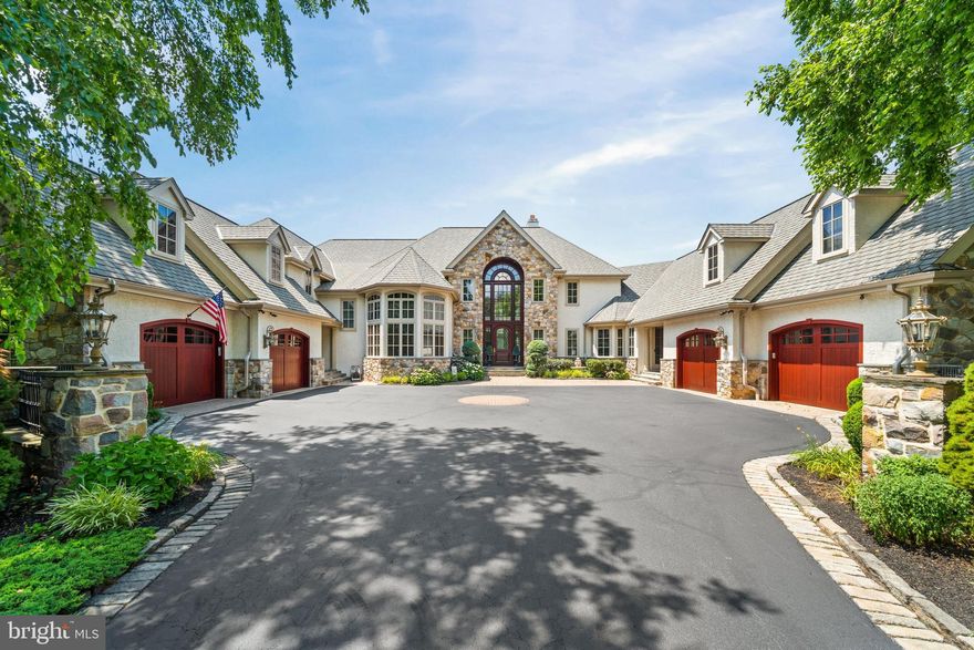 Welcome to this extraordinary custom-built estate in the highly desirable walkable community of Centreville Reserve. Designed by Hillcrest Associates and exclusively built by Dewson Construction with exceptional craftsmanship, this 5-bedroom, 7 full-bath, 2 half-bath residence offers timeless architecture, refined finishes, and true resort-style living. The home opens with a grand two-story foyer featuring gallery-style travertine tile flooring and a dramatic arced bridge overlook, setting the tone for the home’s scale and elegance. Step into a magnificent 25-foot living room with tray ceiling, a full rear wall of windows, and a soaring two-story limestone fireplace — an awe-inspiring focal point. Adjacent is a gracious formal dining room, vast in size and appointed with decorative moldings and arched openings, ideal for elegant entertaining. The heart of the home is a seamless open-concept layout that unites the custom Paradise Kitchen, family room, and breakfast room that features Enkeboll hand carved millwork. The kitchen features granite countertops, handcrafted cabinetry, professional-grade appliances, a large island, and a walk-in butler’s pantry. Just off the kitchen is one of two powder rooms, and a spacious mudroom/laundry combination with built-in cabinetry, utility sink, and folding area. The family room impresses with a soaring ceiling, gas fireplace with custom mantle, and a built-in 150-gallon saltwater aquarium, flowing effortlessly into the breakfast room with built-in benches, a custom volume ceiling, and two 8-foot atrium doors that open to a vast rear deck. An elegant two-story library is accessed through double 12-panel lite doors, showcasing raised-panel cherry cabinetry, custom bookshelves, and a balcony overlook. The private first-floor primary suite offers a true sanctuary with a sitting area and spa-style bath featuring a domed ceiling, whirlpool tub, oversized walk-in shower, dual vanities, an in-suite washer and dryer, and two expansive walk-in closets, each with dressing areas and custom organizers. Upstairs, four additional bedrooms each feature private en-suite bathrooms, volume ceilings, and generous walk-in or storage closets. A large flexible-use room provides ideal space for a guest suite, media room, or game room, and the level includes a third laundry room with built-ins and folding station. The walk-out lower level is extraordinary. The entire rear wall is encased in glass with five sets of atrium doors leading to a huge, covered open-air slate patio that spans the entire width of the home, mirroring the expansive Ipe wood deck above. This level features volume tray ceilings with uplighting, a custom bar with premium appliances (refrigerator, icemaker, microwave, and dishwasher), a pool table area, poker room, and an impressive golf simulation room adorned with custom murals by renowned artist Dan Gotel. A full bath and abundant storage complete this level. The outdoor living experience is unmatched. In addition to the covered patio, there is a second full bath with an outdoor shower for poolside convenience. The 60’ x 22’ heated saltwater pool is accented by a graceful dolphin fountain, cabana, fully equipped outdoor kitchen, stone fireplace lounge, and hot tub, all nestled within lush, professionally landscaped private grounds. Also located on the property is a vast multi-purpose sport court, ideal for basketball, pickleball, tennis, and other recreation — a perfect complement to this home’s resort-style amenities. Additional features include a home theater, wine cellar, fitness room, whole-house audio, smart home automation, and a four-car garage. Just minutes from Centerville Village, Brandywine Valley trails and museums, and top-rated private schools, this estate offers an unparalleled combination of scale, sophistication, and lifestyle in one of Delaware’s most prestigious neighborhoods.