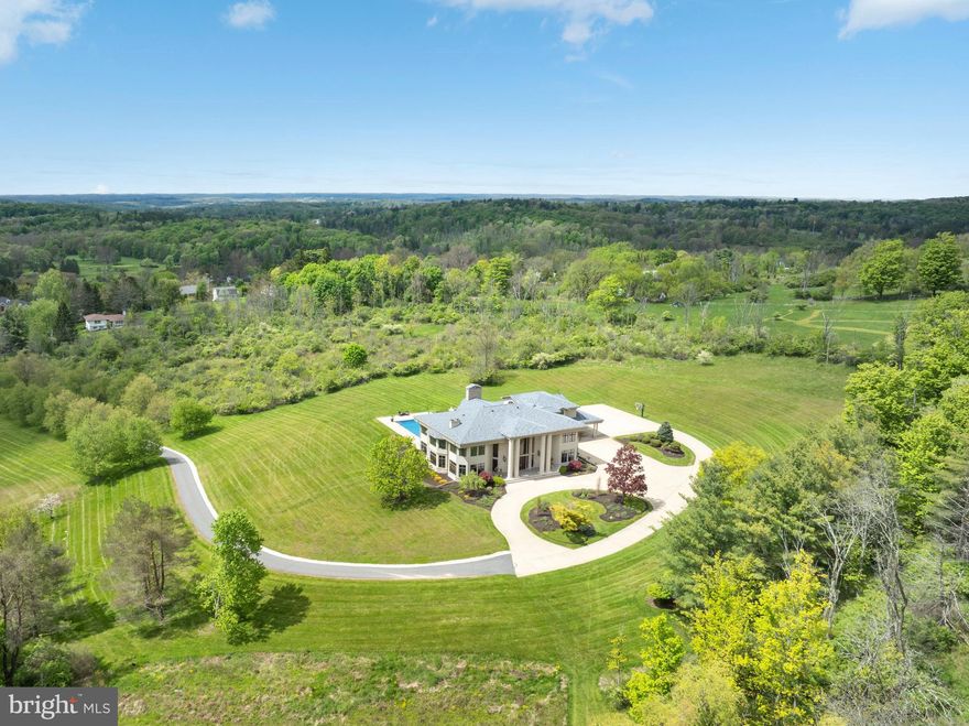 Experience luxury at its finest in this extraordinary contemporary estate nestled in Waverly Township. Offering 24.38 acres and over 10,000 sqft of living space with five bedrooms, five full baths, and two half baths, this residence seamlessly blends sophistication, comfort, and exceptional amenities. The property provides convenient access to Abington Heights School District, shops, dining, country clubs, outdoor recreation in Clarks Summit, and Lackawanna State Park. Approximately 7 miles from Scranton preparatory, 20 miles from Wyoming Seminary, 65 miles from Blair Academy in Blairstown NJ, also nearby University of Scranton, Commonwealth Medical School, Penn State University, 11 miles from Montage Mountain featuring concerts, skiing, water park, and shopping, 16 miles from Elk Mountain Ski Resort, 30 minutes from the Pocono Mountains, and only two hours from both NYC and Philadelphia.

A tree-lined entrance welcomes you to the circular driveway, breathtaking mountain views create a stunning first impression. Designed for relaxation and entertaining, the outdoor living spaces are exceptional, an inground saltwater pool with HydraPure filtration system and electric safety pool cover, expansive patios, a pool/sitting room with bath, inviting back porch, fire pit, and landscaped grounds that create a private retreat ideal for hosting guests. Additional highlights include three gas fireplaces, a elevator with access to the main and second levels, and two separate staircases to the upper floor.

Inside, the dramatic two-story marble foyer features recessed lighting, chandelier, and a magnificent bifurcated staircase. Flowing seamlessly from the foyer, the formal dining room showcases hardwood floors, crown molding, wainscoting, and elegant lighting, the adjacent butler’s pantry offers built-in cabinetry, recessed lighting, hardwood flooring, and access to a second walk in pantry.

The chef’s kitchen is thoughtfully appointed with hardwood floors, two oversized islands, commercial-grade hood vent, wet bar with overhead lighting, double ovens, two warming drawers, separate Sub-Zero refrigerator and Sub-Zero freezer, and a premium six-burner range with optional wok station, cast iron grill, and griddle. Just beyond, the breakfast area overlooks the patio and pool, while the adjoining great room impresses with hardwood floors, coffered ceiling, crown molding, and a striking 29 feet limestone gas fireplace, along with direct patio access for seamless indoor-outdoor living.

The main level also features a spacious media room with built-in cabinetry, speakers, carpeting, and French doors leading outside; an elegant front living room with hardwood flooring and gas fireplace; a private office/study featuring custom mahogany paneling and floor-to-ceiling built-in shelving; two half baths; spacious laundry room; and a full bath with a steam shower.

Upstairs, the luxurious primary suite serves as a private sanctuary featuring recessed lighting, gas fireplace, sitting area, and two expansive walk-in closets with custom built-ins. One closet includes additional flex space ideal for a hobby room or fitness area. The spa-inspired primary bath offers an oversize jetted tub, steam shower, and water closet. Four additional generously sized bedrooms, convenient walk in cedar closet, two full baths, and an additional laundry room finish the upper level.

The expansive lower level offers approximately 5,000 square feet of additional space with vinyl flooring and endless possibilities for recreation and entertainment, along with an additional full bath.

Completing the property is a heated 4-car garage with Tesla car charger and parking accommodations for up to 10 vehicles in the expansive driveway. This exceptional Waverly Township estate masterfully combines timeless elegance, luxurious amenities, and extraordinary living spaces into one unforgettable property. Schedule your private tour today.