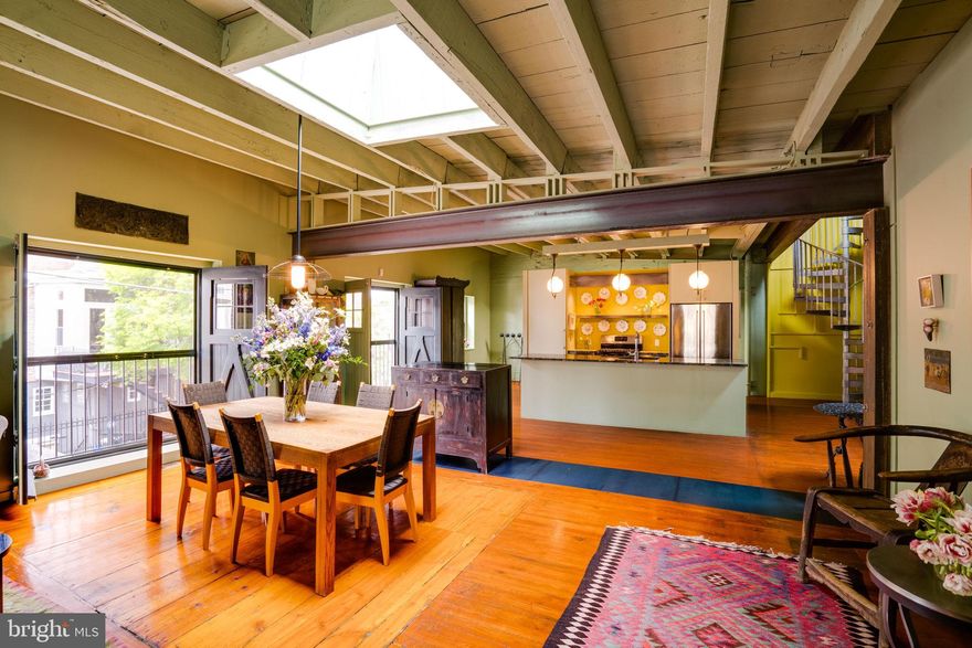 As featured on HGTV, this corner, 2-story Carriage House stretches 45’ wide along Rittenhouse’s quaint Waverly Street. This striking residence, plus art studio, was the dream of a local Philadelphia artist who commissioned renowned architect Alan Metcalfe of Metcalfe Design & Architecture to combine three (3) historic carriage houses into a passionate living & versatile studio space.

Metcalfe successfully blended bold industrial features like oversized windows, exposed beams, and original skylights with the warmth of exposed brick walls, wood floors and streams of natural light throughout. Industrial luxury begins to describe this a one-of-a-kind retreat.

Wherever possible, original detail was preserved adding warmth and character to the home. The interior retains its open plan, vaulted ceilings, and post & beam construction. Modern conveniences have been added such as an elevator that mobilizes you from the 1st floor to the 2nd and the roof deck. The pergola-style deck offers comfort and sweeping views of Philadelphia’s skyline.

The garage, studio space (w/ office,) storage and 1st bedroom with full bath are located on the first floor. The elevated second floor is home to a generously sized living, dining, and kitchen area (w/ pantry;) along with the 2nd and 3rd bedrooms, hall bath, laundry, and 4th bedroom/primary suite.

Overall, the experience leaves you feeling as though you’re living within a work of art.