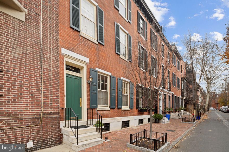 This beautifully renovated circa 1863 home is located on one of the most picturesque and desired blocks of traditional 19th century brick townhouses in the Rittenhouse Square Historic District. This classic townhouse of approximately 3,000 SF, with 4 bedrooms and 3 1/2 baths, is in impeccable condition throughout and is an excellent combination of contemporary updates preserving traditional design. The home features spacious, South-facing light-filled rooms, high ceilings, original moldings and details, and a wonderful floor plan. The Entry Foyer leads to an elegant Living room / Dining room with gleaming oak parquet floors. Custom cabinetry with both shelving and storage cabinets surrounds the Fireplace with a beautiful English mantel. The  living room includes a dry bar enclosed by classic paneled doors. At the back of the original 19th century footprint, double French doors open to a spacious informal dining room/eat-in-kitchen. The first floor layout provides Open/Flexible use of the large living and dining spaces. The recently renovated kitchen features custom Vermont Danby marble counter tops and backsplash, spacious custom cabinets, double-door SubZero refrigerator, a Wolf gas cooktop, and a built-in wall oven with companion microwave/convection ovens. French door glass sliders bring in light and access the original brick paved side and rear garden. A powder room and coat closet complete the first floor. Stairs go down to the finished space for an office/playroom/exercise area and storage. A washer, dryer and laundry sink are separately enclosed. There is additional unfinished mechanical space at the rear of the basement. Straight stairs lead up from the living room to a bedroom/study with custom built-in desk, shelving and cabinetry including large closets and a bay window overlooking the garden with its flowering magnolia tree and has an en-suite full tiled bath. The sunny Primary Bedroom features a second fireplace with marble hearth and surround flanked by closets and a spacious en-suite custom bathroom. This beautifully tiled bathroom has a double marble vanity sink, lighted side cabinets, a full soaking tub, roomy enclosed glass shower, and custom cabinetry with built-in closets and drawers. 3rd floor has 2 additional bedrooms, a full tiled bathroom with skylight, and additional hallway closet and shelved storage. The hallway provides access to a large rooftop space available to reinstall a beautiful deck with great views of the Center City skyline. Additionally, there is a heated sidewalk (snow melt) and 2 separate central air conditioning units. This home is located on a very quiet, low traffic street, between Rittenhouse Square (3 blocks away) and Fitler Square (one block away) and close to Michelin-Starred restaurants as well as Philadelphia’s premier cultural venues. This location provides easy access to Penn, Wharton, Drexel, CHOP, RiverWalk (one of the best in the US), and 30th Street Train Station.