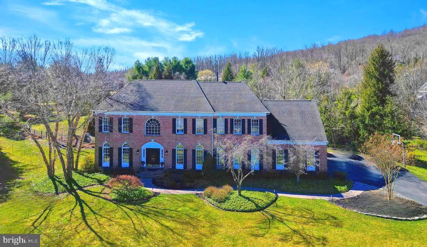 An opportunity like this rarely presents itself on Hibbs Lane, neighboring the vast Jericho National Golf Club, and sophisticatedly located on an oversized corner-lot with a saltwater pool. Discover every imaginable comfort across three fully-finished levels, including 4,936 square feet across the first & second floors, and an additional 1,200 square feet of finished basement space. This stately brick residence dazzles upon entry, with its dramatic sweeping staircase, gleaming 8' wide plank White Oak floors, and freshly painted interiors stylishly setting the tone. You will recognize that no expense was spared as you are met with an airy yet refined atmosphere. Culinary enthusiasts will discover paradise in the remodeled, gourmet kitchen – a truly appetizing space, featuring a Sub Zero 36” refrigerator & freezer, a six burner Wolf Range stove w/decorative hood & a griddle featuring two ovens, pot-filler, floor-to-ceiling custom cabinetry, coffered ceiling, built in microwave,  luxury granite island with room for five chairs and butlers pantry. The adjacent, ethereal sunroom is ideal for a quiet cup of your morning coffee, and the family room (with a recently widened-entry wall) offers even more comfortable yet formal living space. The home’s modernized living room, warm and welcoming, is highlighted by a cozy wood-burning fireplace and newly installed bright shiplap. You will also find a remodeled half-bath, an expansive remodeled office, and an elegant dining room on the first floor. Ascend upstairs, where you will find ample space between the primary suite and secondary bedrooms. The primary bedroom is sprawling, with two walk-in closets, a bathroom suite, and an ideal flex room: perfect for a second office, a yoga space, or even a nursery. The secondary bedrooms feature full bathrooms (including a remodeled Jack & Jill bathroom), bright natural light, and ample closet space. On the home’s expansive lower level, there are diverse areas for indoor entertainment, including a gym, a built-in bar space, built in maple cabinetry for large tv and entertainment system, floor to ceiling tiled full-bathroom, and direct access to the backyard. The stunning nearly-two acre lot is truly showcased in the rear of the home. The saltwater pool & hot tub, al fresco dining area and fire pit enable entertaining on a grand scale, while extensive landscaping and verdant foliage creates a totally private oasis. Additional, notable enhancements include a high-efficiency HVAC System (2 New AC Units & New Furnaces, Infrared Lighting), new water treatment system, recently applied garage floor epoxy and a new Sonos Sound System and camera-monitored doors. Make a lifetime of memories, while enjoying exquisite touches throughout this home, a short walk across the street for a round of golf or the vibrant town of New Hope, PA (just a 5-minute drive away, fabulously exposing you to an exceptional cultural scene of fine dining, shopping, and art). 1 Hibbs Lane is a poster child for elegant Bucks County family living, in one of the areas finest & most desirable neighborhoods.