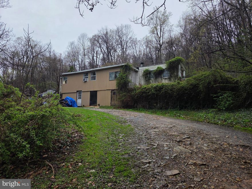 Discover over 6 beautiful acres (+/-) on 1216 Roberts Valley Rd, Harrisburg — This property offers a unique combination of privacy, natural beauty, and practicality. The land is equipped with a good well and good septic system, providing a strong foundation for future building plans. A 12x60 mobile home and a 2-car block garage with 12-foot ceilings are included, but the true value lies in the land. The existing structures are in poor condition and are being sold as is. Enjoy the abundant wildlife — deer, turkey, and other game are frequent visitors — and the serene, wooded surroundings. With easy access to nature yet close to amenities, this is an excellent building lot for your dream home, retreat, or investment. Don't miss this rare chance to own a prime piece of Roberts Valley!