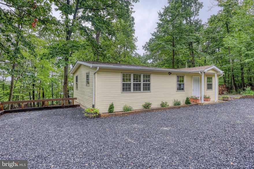 MOTIVATED SELLER - bring us your offers! Welcome to this beautifully renovated 2-bedroom, 1-bath ranch-style home nestled in the peaceful, private community of Wild Acres. Surrounded by trees, this cozy 960 sq ft retreat offers the perfect blend of modern updates and natural charm. Inside, you’ll find a bright, refreshed interior with thoughtful updates throughout. Major improvements—including a new well, septic system, and HVAC—offer added value and peace of mind. The open living space flows nicely into the kitchen, creating a comfortable layout for everyday living or entertaining. Step outside to enjoy the charming back deck just off the bedroom—perfect for morning coffee or unwinding in the quiet of nature. Whether you're searching for a full-time home, weekend escape, or investment opportunity, this property offers a relaxed lifestyle in a scenic setting. Additional notes: The property is approved for a one-bedroom septic system, though it is currently configured as two rooms. Some foundation improvements have already been completed, including drainage installation, sealing, and partial block replacement. The home is priced accordingly and being sold as-is, presenting a great opportunity for the next owner to make it their own.