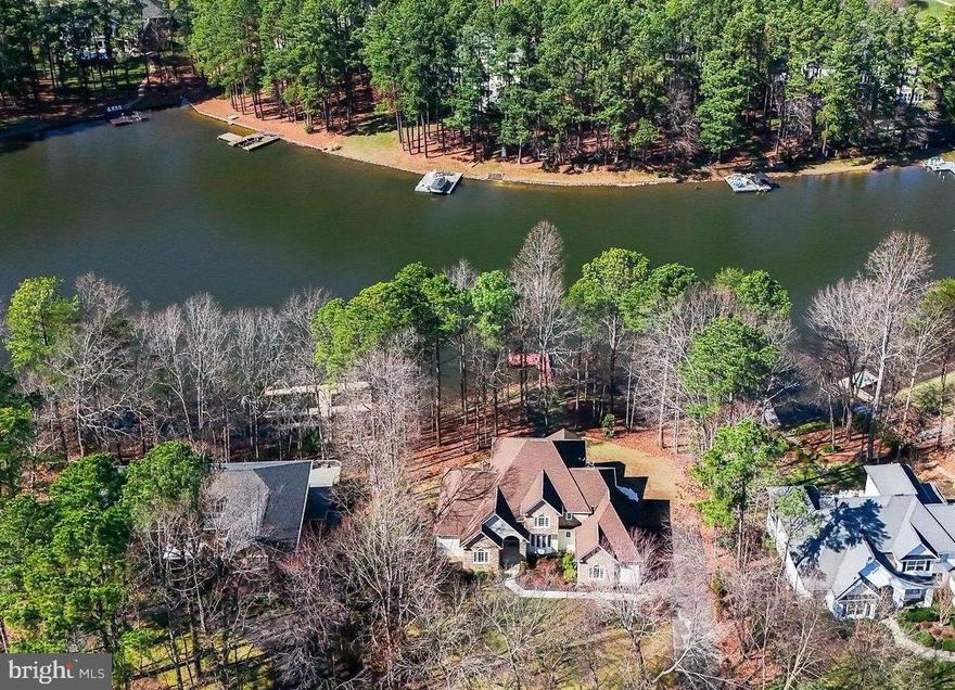 Enjoy the ultimate in  lakeside living with this beautiful waterfront home, located inside the gated luxury community of Fawn Lake.  With 165 feet of peaceful shoreline on a quiet cove, 11502 Henegan Place is a grand traditional-style home in a well-established section of the neighborhood, merely a short walk to all the resort style amenities of Fawn Lake.  Entering through the impressive double doors framed by a large Palladian window, you are welcomed by a stately foyer with brilliant hardwood floors extending into the formal dining room to the right that features chair railings, a tray ceiling, and crown moldings.  Past the wide, elegant staircase, the two story family room spotlights an enchanting view of the lake through its "wall of windows," accented by a spectacular gas fireplace with stonework from floor to ceiling.  Through the Family Room's French doors, you will find a spacious gourmet kitchen, well-equipped to handle all your storage and organizational needs while the screened in porch off the kitchen serves as a lovely space to take in the lake views. With brand new stainless steel appliances and a generous breakfast nook, this kitchen is bound to be an entertaining hub for family and friends in your new home, especially with its additional staircase leading to the guest bedrooms upstairs.  The main floor primary suite has brand new carpet and easy access to the rear deck, providing a perfect retreat to take in the sunrise and sunset views by the water.  The primary bath offers a double vanity with brand new countertops, large soaking tub, oversized shower and ample walk-in closet.  A generous study with gleaming hardwood floors serves as a remarkable space for working from home.  Upstairs, you will find a sizeable en suite bedroom that includes a walk-in closet and full bath with brand new countertops.  Two additional secondary bedrooms with a Jack-and-Jill style shared bath complete the upper level.  Descending downstairs to the finished basement, a massive recreation room awaits, ready for all of your lakeside cookouts with friends and family!  A wet bar with gorgeous wooden cabinetry and granite countertops compliments the recreation room while the gas fireplace creates a warm, welcoming ambiance.  Guests can take advantage of the convenient half bath on the lower level, in addition to the substantial fifth bedroom that includes its own en suite full bath.  Storage options continue on the basement level with a carpeted storage closet and separate unfinished storage space, perfect for all the water toys you'll want to have on hand for  fun in the lake!  Outside, an inviting outdoor living space exudes friendly charm with a screened in porch just off the breakfast nook in the kitchen, adjoined to the deck that extends across the rear of the home.  Recent updates to the home include brand new countertops and fixtures in the main and second level bathrooms, new carpet in the primary bedroom and family room, new kitchen appliances, new laundry room flooring, new windows around the home, and a one year old upper level HVAC system. Perfecting this 0.71 acre lot is the 165 feet of shoreline along a quiet cove in Fawn Lake.  The private dock allows for countless hours of fun for swimming, fishing, boating, kayaking, and more.  Fawn Lake is Fredericksburg's favorite gated, lakeside community offering a 288 acre recreational lake, miles of walking/jogging/biking trails, a sports park with baseball, pickleball, soccer, and basketball, playgrounds, a dog park, marina, beach, and country club membership opportunities.  Schedule your showing today to experience the luxurious lake life only Fawn Lake can offer!