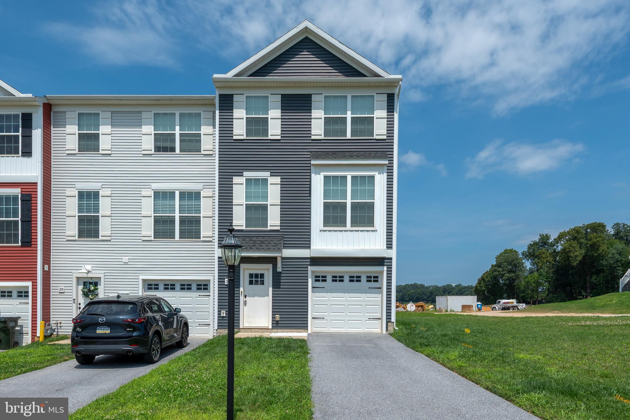 Welcome to this beautifully maintained 3-bedroom, 2.5-bath end-unit townhouse located in the highly sought-after Dallastown Area School District. Nestled in this family-friendly community, this home offers 1,470sq. ft. of comfortable living space, and sits on a desirable, large corner lot with both a spacious backyard and an additional side yard, perfect for outdoor entertaining. Step inside through the front door to find convenient garage access and a finished walk-out basement complete with sliding glass doors that lead to the yard, ideal space for a home office, playroom, or an additional family room. Upstairs, the main level welcomes you with a bright and open floor plan featuring a spacious living room, modern kitchen with dining area, and a convenient half bath, perfect for hosting guests. The upper level boasts a generous primary suite with a walk-in closet and a private en suite bath. Two additional bedrooms and a large guest bathroom. This home is part of a welcoming community that includes a play area for children and is located close to local amenities, shopping, and major commuter routes. Don't miss your opportunity to own this lovely end-unit townhouse!