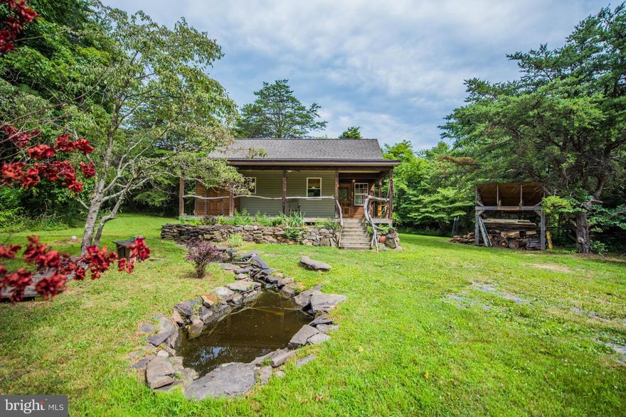 Unique custom built cabin in quiet setting. Beautiful woodwork and finishes inside. Lots of built-in storage. Large open porch and a screened in porch. Landscaping and plenty of room for animals and a garden. Completely remodeled in 2006. This is the perfect retreat only 45 minutes from Winchester. You have to see it to appreciate it!