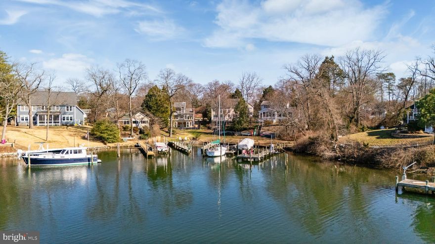 Enjoy waterfront living in this beautiful home on Cypress Creek in Severna Park's desirable Manhattan Beach community. Lovingly maintained and thoughtfully updated, this charming home offers the perfect setting for boating enthusiasts and those who enjoy entertaining by the water. Situated on a .58-acre lot with a gentle slope to the shoreline, the property features 76' of waterfront and a private pier in a protected cove with 5-6 feet MLW and space for 2 boats. From here you can easily reach the Magothy River and the Chesapeake Bay just beyond. The outdoor spaces are ideal for relaxing or hosting gatherings, with a spacious deck overlooking the water and a peaceful spring-fed goldfish pond surrounded by nature. The serene setting attracts a wide variety of local wildlife throughout the year and provides wonderful opportunities for avid bird watchers. Inside the home you'll find a warm and inviting living space with three bedrooms and two full baths, along with a bright four-season sunroom that captures beautiful water views. A main-level primary bedroom and remodeled full bath with a laundry hookup provides the option for convenient one-floor living. Upstairs you will find two additional bedrooms and an updated full bath. The unfinished walk-out basement includes a laundry area, workshop space and plenty of storage. Many wonderful interior details include newly refinished hardwood floors, classic knotty pine wood paneling, custom wood trim, french doors, and a masonry fireplace in the family room. Recent updates and improvements include fresh neutral paint (2026), new HVAC (2025), extensive landscaping (2023), new washer, dryer & electric range (2023), new paver driveway & walkway (2022), EV charging outlet (2022), updated flooring throughout (2021), jet ski lift (2021), and a new refrigerator & dishwasher (2021). The property also features dual driveways providing abundant parking and additional space for boats. Located in the award-winning Severna Park school district and within the highly desirable Manhattan Beach community, residents enjoy access to three community beaches, a boat ramp, a playground, and a community center. Whether you are looking for a full-time waterfront retreat, a place to entertain friends and family, or the opportunity to expand in the future, this Cypress Creek property offers a perfect combination of location, lifestyle and water access. Be sure to click the film reel icon in the listing for an interactive Virtual Tour!