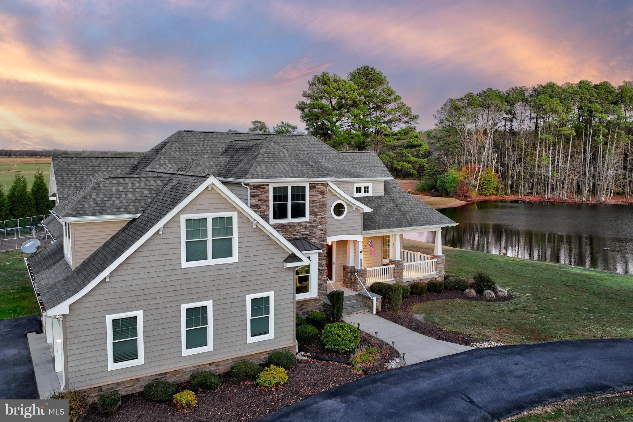 Welcome to 8475 New Hope, a stunning craftsman-style retreat set on a secluded 2-acre lot overlooking a tranquil pond. Offering the perfect blend of privacy and natural beauty, this picturesque home provides a peaceful escape while remaining just 20 minutes from both Ocean City and Salisbury. Thoughtfully designed to harmonize timeless elegance with modern comfort, this exceptional property is a true sanctuary. A long, circular driveway and mature landscaping set the stage for the striking curb appeal. The home’s exterior showcases multiple gabled peaks, shake siding, stone accents, and a welcoming covered front porch—an idyllic spot to enjoy peaceful morning coffee. A spacious side-entry two-car garage seamlessly integrates into the home’s design. Step through the handsome double wooden entry door with a transom window above into an inviting foyer that exudes warmth and sophistication. The main living areas are graced with beautiful wood-look porcelain tile flooring, enhancing both style and durability.
The heart of the home is the expansive gourmet kitchen, a true showpiece featuring gleaming quartz countertops, a chic tile backsplash, craftsman-style white soft close cabinetry with elegant crown molding and under-cabinet lighting. A sprawling island offers plenty of space for casual dining and entertaining, while high-end appliances—including a convection cooktop, range hood, and wall oven —cater to the most discerning chefs. Thoughtful details, such as two appliance garages—one on the countertop and another tucked within the island with a pull-out and pull-up mechanism—keep the space both functional and pristine. A dining area bathed in natural light sits adjacent to the kitchen, highlighted by a statement chandelier. Just down the hall, a walk-in pantry offers even more convenient storage options. The open-concept design flows effortlessly into the spacious living room, where floor-to-ceiling windows frame calming views of the countryside and pond. A striking coffered ceiling and a dramatic stacked-stone fireplace add warmth and character, while a set of transom doors leads to the front covered porch, creating a seamless indoor-outdoor living experience. The main-level primary suite is a private oasis, complete with a tray ceiling, a generous walk-in c custom closet featuring built-in shelving, hanging spaces and drawers. The spa-like en suite bath has modern tiled flooring, dual vanities and a custom walk-in tiled shower. Also on this level, the well-appointed laundry room is outfitted with an Energy Star LG ThinQ washer and dryer, as well as built-in storage lockers, offering both convenience and organization. A private home office exudes sophistication with elegant wainscoting that add character to the space and provides the perfect space for remote work. A stylish powder bath completes the first floor. A beautifully crafted turned staircase leads to the upper level, where a large family room provides the perfect space for game nights and movie marathons. Two additional bedrooms—one with an en suite bath—offer comfortable accommodations, while a spacious exercise room provides the flexibility for a home gym or hobby space. This exceptional property features an energy-efficient geothermal system, providing year-round comfort with lower utility costs and environmentally friendly heating and cooling. The property is also equipped with four hardwired security cameras, providing added peace of mind. Outdoor living is just as spectacular, with a charming porch off the kitchen leading down to a handsome paver patio, perfect for summer gatherings. The property is also equipped with four hardwired security cameras, providing added peace of mind. Enjoy the tranquility of nature, stunning water views, and the refined elegance of this one-of-a-kind home. Schedule your showing appointment today.