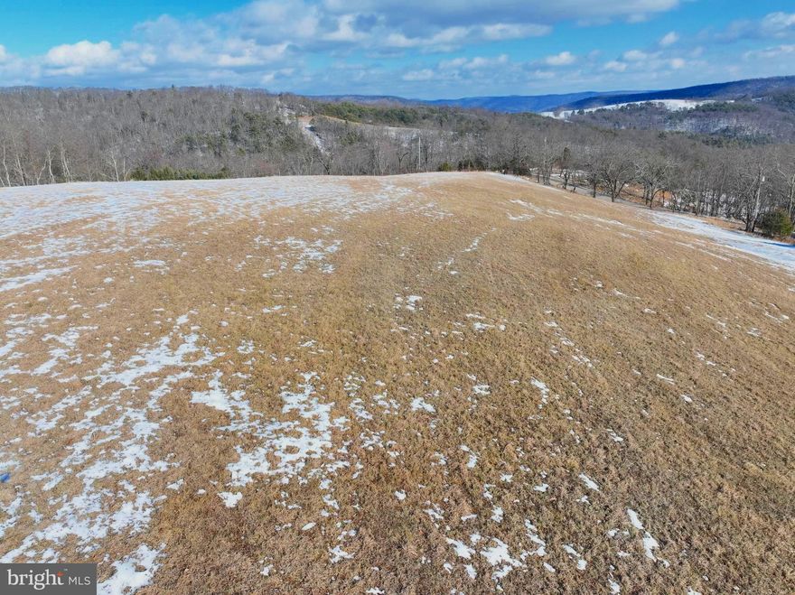 There are properties you scroll past, and then there are properties that stop you cold. This 17.55-acre tract along Shenandoah Mountain Road in Mathias, Hardy County, West Virginia, is the kind that resets your system the minute you step out of the truck. It offers direct access from a county-maintained road—no questionable easements, no complicated entry points, and no HOA drama. Completely unrestricted, this is real mountain ground where you decide what gets built and how it gets used. The makeup of the land is exactly what serious buyers look for. You have a strong mix of densely wooded acreage for privacy, wildlife cover, and timber value, combined with an open field that gives you immediate usability for a homesite, cabin location, or food plot. Electricity runs along the property boundary, making development straightforward without sacrificing the off-grid feel so many buyers want. The elevation delivers both sunrise and sunset views—something you don’t find on every tract. Morning light breaking over the ridges and evening skies burning down behind Shenandoah Mountain become part of the daily routine here.
From a hunting and recreational standpoint, this property checks the boxes. Hardy County is known for solid whitetail genetics and bear, and the blend of woods, edge, and open ground creates natural movement and bedding areas. Whether you’re setting stands, planting food plots, or holding the land as a long-term investment, the terrain supports it. This is ground that can be enjoyed immediately and improved over time. Location matters, and this tract strikes the balance. Secluded enough to feel like a true escape, yet within two hours of Washington, D.C., it’s a realistic weekend retreat and a smart long-term hold. You’re far enough away to breathe, yet close enough to make it practical. This is not a cookie-cutter HOA lot. It’s not controlled by covenants or someone else’s vision. It’s 17.55 acres of West Virginia mountain land where you call the shots—cabin, barndominium, full-time residence, hunting retreat, or simply a hard asset in a region that continues to draw buyers looking for space and freedom.
Good mountain tracts with county road frontage, electric available, usable open ground, timber, and real views do not sit around. If you’ve been waiting for a clean, usable piece of Hardy County ground that actually makes sense, this is it. Walk it once—you won’t regret it.