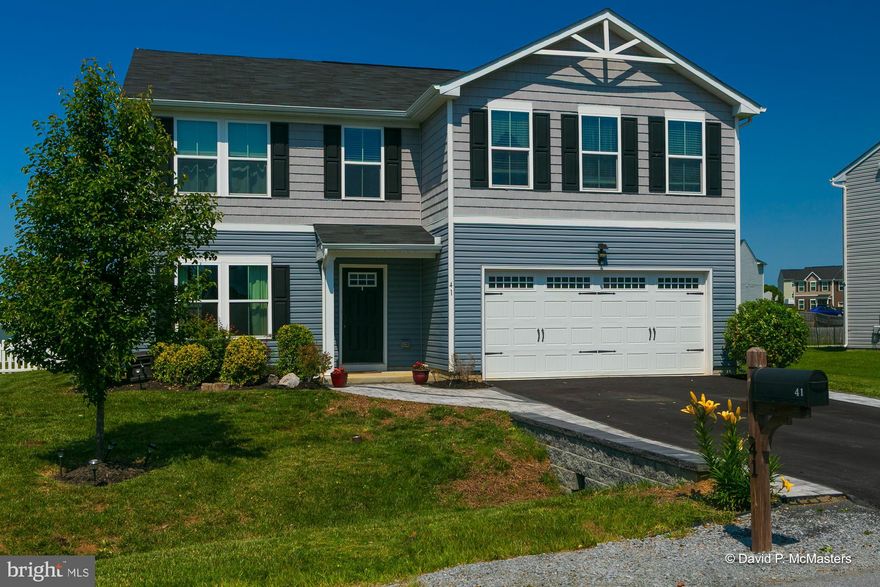 This 5 bedroom 2.5 bath home is a well maintained gem.   No need to worry about crawl space issues or radon because this home sits solidly on a slab.  Ideally located with EASY ACCESS TO WINCHESTER AND NORTHERN VIRGINIA AND I-81.  The main level great room can be arranged with your furniture to provide the style you create.  The fully equipped kitchen extends to a large eat-in area leading to a completely wonderful flat stone patio with a fenced backyard.  The 2nd floor bedrooms are all spacious, 
the primary bathroom includes a walk-in shower,  walk-in closets and the other bedrooms are serviced by a hallway full bath.   The premium lot actually extends beyond the decorative fence into the common area for use by this owner.   The kitchen includes a flat top range,  a built-in microwave,  back splash,  dishwasher,  disposal and a water filtration system that leads to the refrigerator for purified drinking and ice,  2 pantries/ utility closets with plentiful shelving  and a center breakfast island.   A large 1/2 bath  for convenience also  occupies the main level.   Access to the attached 2-car garage from the kitchen is in place and  is loaded with shelving. You will notice the interesting driveway concept that offers built in walkway areas on both sides to allow clean walking from your vehicles to the front door.   WIFI with high speed internet  that are essential to the owner's home business are available..and yes the mounted tvs DO CONVEY.    As an added bonus, a specified area within this community is set aside with a children's play area,  as well as a dog park and is located a short distance from this home!  Don't wait on this one!