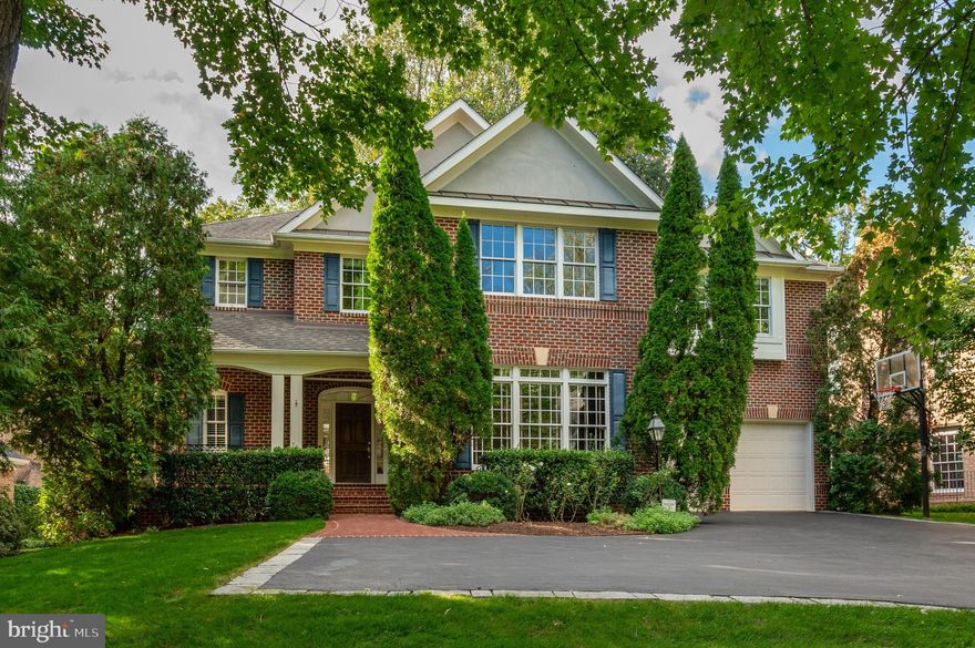 Set within one of Bethesda’s most coveted neighborhoods, this distinguished residence, offering nearly 6,500 square feet of beautifully finished space, gives the home an excellent flow for entertaining and everyday living. Designed for both intimate family moments and grand-scale entertaining, the home rests on a professionally landscaped .42-acre lot, where stone walls and lush plantings create a private sanctuary. A soaring two-story foyer, graced with gleaming hardwood floors and a sweeping curved staircase, introduces the main level. The formal living room, crowned with 19-foot ceilings and a striking oversized window, flows seamlessly into a refined formal dining room framed by bay windows and a charming window seat. The heart of the home, the expansive kitchen, is outfitted with custom wood cabinetry, a center island with seating, and a generous informal dining area that opens to the deck terrace and gardens. Adjoining this space, the family room offers built-ins, a stone hearth gas fireplace, and direct access outdoors. Completing the main level is a distinguished library, powder room, and oversized two-car garage.

Upstairs, four spacious bedrooms include an exceptional primary suite. Walls of windows overlook the verdant rear grounds, while tray ceilings, a serene sitting area, and a custom walk-in dressing room elevate the sense of luxury. The primary ensuite features dual vanities, a jetted soaking tub, and a glass-enclosed shower with dual showerheads. The fully finished lower level offers a recreation room, mirrored gym, home theatre with projection system and luxury seating, plus a guest suite with full bath—perfect for hosting extended family, an au pair, or overnight visitors. The rear exterior offers an expansive deck, yard space and play house. Beyond its interiors, this home’s prime Bethesda location places it within close proximity to Walt Whitman High School, the Capital Crescent Trail, and the boutiques and dining of downtown Bethesda, with easy access to the Beltway.