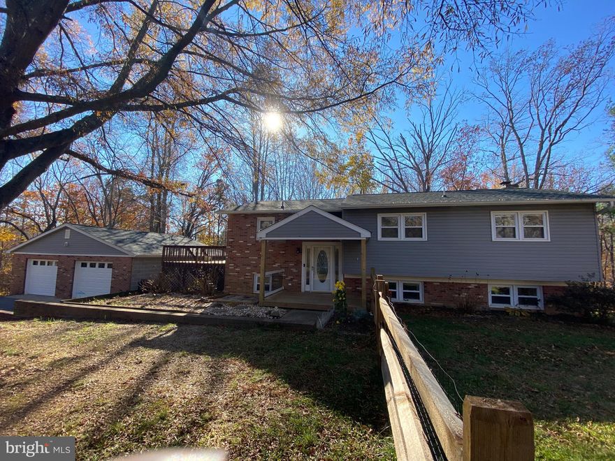 Spacious home on  secluded 3.49 acres. Home features 2 full kitchens so plenty of room for addl family members if needed or possibly a home day care. Hardwood floors thru out the upper level and ceramic in the main floor kitchen. Downstairs has wood fireplace with brick mantle, full bath, full kitchen, and living area. Walk out doors in the  basement so it has its own entrance. Large wrap around deck leads out to fenced in yard. Many large items replaced recently. Roof is 5 years old, HVAV approx 1 year ago, new garage doors, siding and gutters. Water heater was replaced 2-3 years ago and the windows have been replaced.  Oversized 2 car detached garage with plenty of room for cars, workspace and yard items.