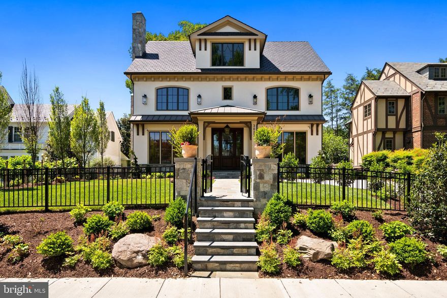 Nestled in the heart of Wesley Heights, 3022 44th Place NW is an extraordinary newly constructed residence by renowned builder Chryssa Wolfe with Hanlon Design Build. Spanning over 7,000 square feet across four meticulously finished levels, this exceptional home offers 7 bedrooms, 7 full bathrooms, and 3 half bathrooms, pairing timeless architectural detail with sophisticated modern living throughout. An elevator services all four levels, providing effortless access throughout the residence.

A gracious entry introduces soaring 11-foot ceilings, exquisite custom millwork, and beautifully proportioned spaces that establish the tone for the home’s elevated design. The formal living room is anchored by coffered ceilings and a striking fireplace with a custom stone mantel, creating a sophisticated setting for entertaining. The formal dining room, also enhanced by coffered ceilings, is ideally suited for both intimate dinners and larger gatherings.

Designed for both everyday living and entertaining, the rear of the home opens seamlessly into a spectacular kitchen and family room. The chef’s kitchen features premium Taj Mahal-inspired quartz countertops and backsplash details, custom cabinetry, a six-burner Wolf range with griddle, Sub-Zero refrigerator, dishwasher, expansive island seating, generous table space, and a walk-in pantry. Adjacent, the expansive family room showcases coffered ceilings, custom cabinetry, and dramatic cantina doors that fully retract to create a seamless connection to the outdoor living spaces. A thoughtfully designed wet bar with wine refrigerator and sink further enhances the space for effortless entertaining.

The main level also includes two thoughtfully positioned powder rooms—one serving interior guests and another conveniently located near the outdoor entertaining spaces and backyard. Designed to function as an elegant changing room, the secondary bath and mudroom area features custom cabinetry, towel storage, and refrigerated beverage drawers for added convenience and comfort.

The first upper level features four generously proportioned bedrooms, each with large closets complete with custom storage systems and en-suite bathrooms. The primary suite serves as a luxurious private retreat, offering two expansive walk-in closets and a spa-inspired bathroom with a custom dual vanity, freestanding soaking tub, radiant heated floors, oversized shower, and private water closet. A spacious, well-appointed laundry room completes this level.

The second upper level provides remarkable flexibility with two additional generous bedrooms, two full bathrooms, and a stunning lounge or office space with beautiful treetop views toward the Washington National Cathedral. Multiple storage closets, including a cedar-lined closet, further enhance the functionality of this level.

The lower level was designed to offer both comfort and versatility, featuring an expansive family room with fireplace and a well-equipped kitchenette complete with sink, refrigerator drawers, and built-in microwave. Additional amenities include a climate-controlled wine storage room, fully equipped gym with infrared sauna, private guest suite with en-suite bath, additional laundry room, and abundant storage throughout. A separate exterior entrance leads to a beautifully designed mudroom with custom built-in storage, integrated seating, striking stone flooring, and a sophisticated powder room ideal for guests accessing the outdoor spaces.

Set well back from the street and framed by professionally designed landscaping, the residence offers exceptional privacy and curb appeal. The fully fenced front yard features expansive grassy areas ideal for recreation and outdoor enjoyment, while private parking further enhances the home’s convenience.

Rarely found in the city, the outdoor spaces were designed as a true extension of the home’s living and entertaining areas. The backyard features a built-in grilling station, heated swimming pool wit
