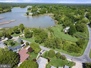 Nantucket meets the Bay in this 5 bedroom, 3-4 bath Carriage Style Waterfront. This Coastal Charmer has views from 3 sides and offers a Community Boat Ramp next door and Sandy Bayfront Beach directly across the street. Recent renovations include handsome hardwood floors, upgraded baths, new kitchen, new windows, new doors and new siding. Main level offers two bedrooms - ideal for in-law or extended family. Second level offers 2 bedrooms with full bath and a huge water view Master Suite with a sprawling balcony. Still time to customize and add your finishing touches to make this home uniquely yours. There is not a garage but with 1.5 acres there is plenty of room to add.