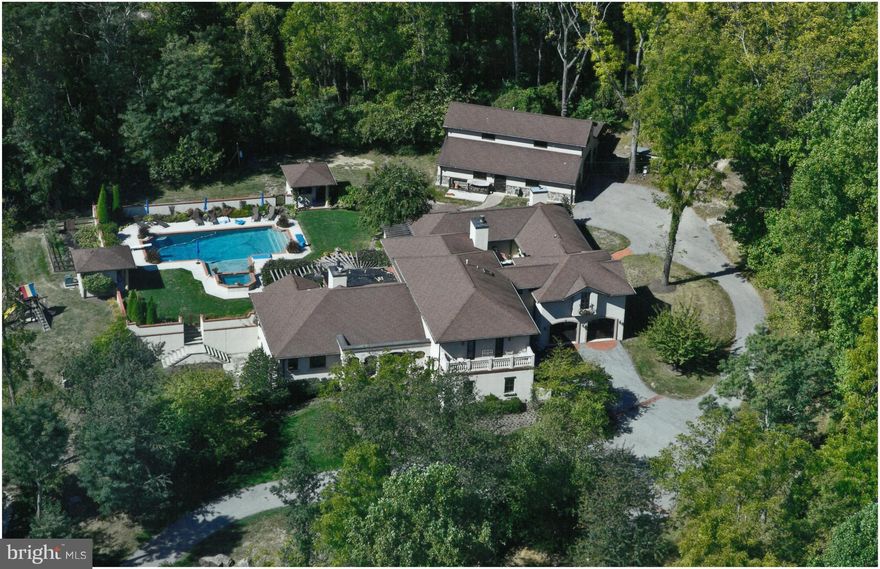 Stunning reminiscent of the best Napa Valley architecture w/ open design for easy entertaining. Features the highest quality craftmanship blending finest materials, authenticity & style. Insulated Concrete Construction, Great Rm w/ open beam ceiling, 2-story stone FP, radiant heat, walled courtyard w/ in-ground heated pool, in-law suite, Adirondack style Hobby Barn & more. Unparalleled & private.