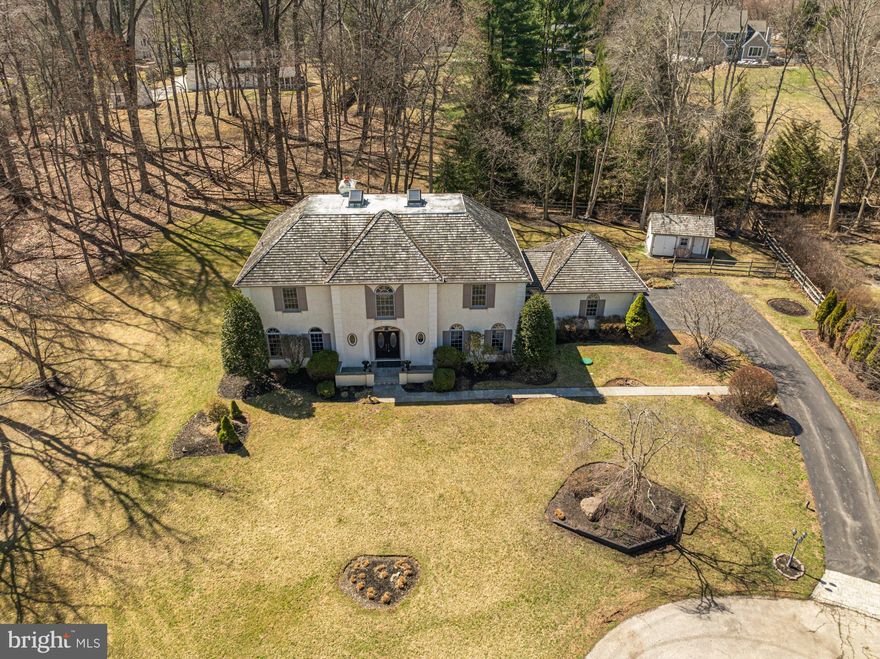 New price Alert! Welcome to 516 Sugartown Rd – a stunning 4-bedroom, 5-bathroom home at the end of a private cul-de-sac is nestled on a serene 1-acre wooded lot in a desirable Devon, and NO HOA. This exceptional residence boasts an impressive slate stone walkway leading to a grand entrance, where a circular marble foyer with soaring ceilings and a spectacular chandelier sets the tone for elegance. The expansive first floor offers multiple living spaces, including a formal living room with tall windows, a wood-burning fireplace adorned with a detailed mantle, crown molding, and French doors that open to a private deck. Adjacent to the living room, the study features hardwood floors, built-in shelving, abundant natural light, and a wet bar with an entertainment sink. The grand dining room, situated next to the study, is bathed in natural light and features high ceilings, crown molding, and chair rail—perfect for hosting gatherings. The family room is a cozy retreat with a full brick wall, custom built-in shelving, art lighting, a gas-burning fireplace, and French doors that lead to the rear deck. The spacious kitchen offers ample storage, a delightful breakfast area, and a large bay window with a deep seating bench overlooking the maintenance-free rear deck. This space seamlessly connects to the outdoors, making it ideal for indoor-outdoor entertaining. Additional main-floor highlights include 2 powder rooms and a laundry/Mud room with cabinets, a utility sink, and direct access to the attached 3-car garage, complete with Garagetek flooring. Upstairs, the oversized primary suite is a private sanctuary with a dressing room, en suite bathroom, and spacious his-and-hers cedar walk-in closets. Two additional well-sized bedrooms share a full hall bath, and a third bedroom features its own en suite. All bedrooms boast custom cedar closets for ample storage. The finished walk-up attic provides a versatile playroom with skylights and a custom mural, along with extra storage space. Outdoor living is a dream with a back deck offering exceptional privacy and serene views of the expansive yard, perfect for relaxation or entertaining. The beautifully landscaped front, side, and rear beds feature charming landscape lighting, and a custom shed adds to the property’s appeal. Located in the award-winning Tredyffrin-Easttown School District and just minutes from major roads, shopping, and dining, this exceptional property offers the perfect blend of privacy, elegance, and convenience. Upgrades include but are not limited to Cedar roof, Slate patio and walkway, whole house generator, new HVAC, New ejector pump, central vac system, French drain system in the basement and surrounding the property, Jenn-Air appliances and New custom shed. Don’t miss your chance to own this exquisite home in Devon!