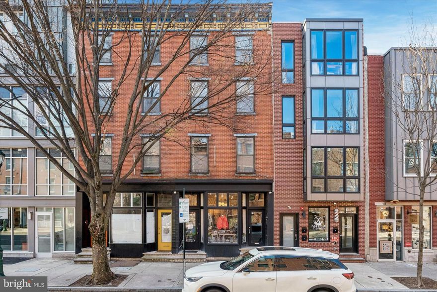 Step into a unique opportunity on vibrant South Street. This expansive, grandfathered four-story brick-front building offers over 2,900 square feet of combined residential and commercial space in one of the city’s most sought-after locations, bordering Rittenhouse Square and Graduate Hospital. Fully tenant-occupied, the mixed-use property includes a ground-floor retail space, a second-floor one-bedroom apartment, and a spacious bi-level two-bedroom apartment spanning the third and fourth floors.

The storefront features its own private entrance, separate from the residential units, and enjoys prime positioning along South Street. A large bay window provides excellent visibility and display potential, while the interior boasts high ceilings, a private office, a powder room, and access to a small rear yard. A full basement, accessible from both the store and the street via Bilco doors, adds valuable storage and functionality.

Above, the residential units are bright and thoughtfully designed. The second-floor one-bedroom apartment includes hardwood floors and a private rear balcony. The upper bi-level unit offers a more expansive layout with two bedrooms, hardwood flooring, skylight, and access to a large private deck. Both apartments, along with the retail space, are equipped with separate central air conditioning systems that are only a few years old.

Originally custom-rehabbed in the 1980s by an architect, the property was designed to maximize natural light throughout. This attention to detail is evident even in the shared staircase, where exposed brick and abundant natural light create a warm, inviting transition between levels. Each unit also includes additional storage space for added convenience. 

Located just steps from the historic Royal Theatre and surrounded by an eclectic mix of restaurants, shops, theaters, and neighborhood amenities, this one-of-a-kind property offers immediate access to Rittenhouse Square, Graduate Hospital, and Broad Street.