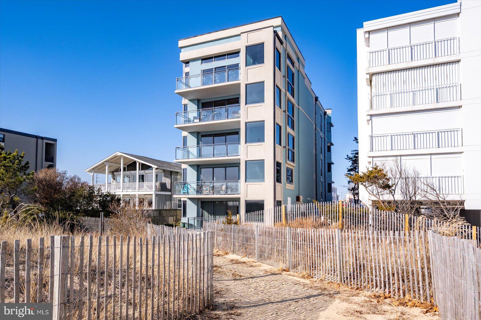 Discover unparalleled luxury and coastal living in this spectacular 1970 sq ft -3-bedroom, 3.5-bathroom oceanfront condo, located in an exclusive boutique building in Ocean City, MD. Offering breathtaking panoramic views of the Atlantic Ocean, this meticulously designed home is a true sanctuary. As you enter, you are immediately greeted by a spacious open concept living area featuring stunning hardwood floors and large windows that invite natural light and incredible ocean vistas. The gourmet kitchen is a chef’s dream, complete with premium Sub Zero and Wolf appliances, custom cabinetry, and sleek granite countertops. The kitchen seamlessly flows into the family and dining areas, creating an ideal space for both everyday living and entertaining. A cozy fireplace adds a touch of warmth and elegance to the space. The luxurious primary suite is your personal retreat, offering a serene ambiance and an en-suite bathroom with a jetted tub, a tiled shower, and dual vanities. The two additional bedrooms are equally impressive, each with its own en-suite bath, providing ample space and privacy for family and guests. Enjoy the soothing sounds of the ocean from the comfort of your home and start your day with stunning sunrise views from the private balcony. Modern touches such as custom tilework, plush carpeting, and a full-size laundry room with additional storage ensure that every detail has been thoughtfully designed. Additional features include secure lobby access, elevator service directly to your unit, two dedicated parking spaces, and a storage closet. With proximity to shopping, dining, and entertainment, this exceptional condo combines the best of luxury living and coastal convenience. Whether you’re looking to make this your year-round residence or a seasonal getaway, this oceanfront oasis offers the perfect blend of elegance, comfort, and stunning natural beauty. Sold fully furnished. Schedule your private tour today!