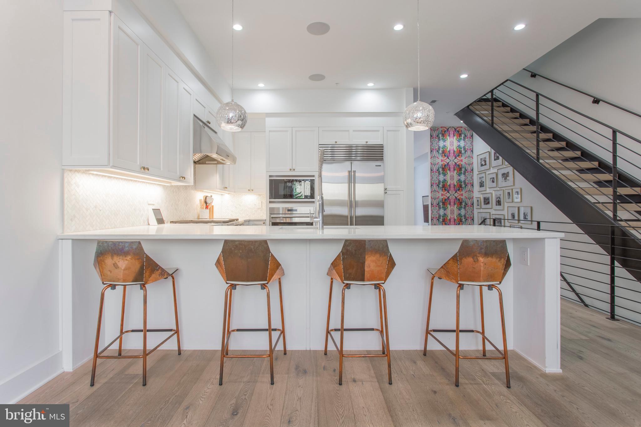 Rare and stunning designer home in Meredith Catchment. 2 year old new construction with 8 years remaining on 10 year tax abatement. This home features striking design and personality with every upgrade and amenity imaginable. The entire house features WiFi enabled Lutron light and security system, Ring Door bell, Nest Thermostats and motorized blinds. Have a dog? The HOA has its own private gated dog park! Walk into the first floor entry where you have a large coat closet with custom storage systems and up to the open dining area and kitchen. The dining room features stylish wallpaper on the ceiling and an ornate light fixture and space for dining table that can accommodate 10-12 people. The gourmet kitchen features a stainless steel Wolf cooktop, double wall ovens, an extra large Sub Zero french door refrigerator and a beverage fridge. The extra large island and counter tops are white marbled Quartz. The pantry and cabinets feature under-cabinet lighting custom storage solutions as well. The house is wired for sound with built-in speakers in the kitchen and on the roof deck. The conveniently located powder room has simple and stunning European wallpaper with rows of white book shelves. Down a few steps on the left is the elevator which features hardwood floors and goes to all floors of the house, including the basement and roof deck. The rear living area is perfect for quiet family time. This room features 12+ ft ceilings and a wall of windows with access to the rear yard and parking. This room also features another large walk-in storage closet and a gorgeous central light fixture. The rear patio features built-in storage and easy access to the gated parking space. The parking space, located directly behind the house has a dedicated Tesla Electric Car charger. Walk up your floating wood and metal stair case to the second floor where there is a large storage closet, two ample sized bedrooms with en suite bathrooms, custom wall paper and walk-in closets with custom storage systems. The rear bedroom features a tub/shower combination, while the front bedroom features a walk-in shower. On the 3rd floor is a powder room easily accessible for the roof deck as well as the full floor Master Suite. Enter the Master Suite through the custom 4 ft wide entry door. The Master Bedroom has been intelligently divided to accommodate a separate en suite office. There are large "his" and "hers" walk-in closets as well as a separate vanity with custom fanciful showgirl wallpaper. The master bathroom is enormous, has a freestanding tub, chandelier, a double vanity and large walk-in tile shower with bench. The roof deck incredible roof deck has expansive city and river views, exterior lighting and a BBQ. The basement is full and finished with a 12+ ft ceiling height, tons of storage, mechanicals, the in-law suite and full bathroom. This house is a true Center City Oasis. Walking distance to the Italian Market, Whole Foods, Seger and Palumbo Parks and easy access to 76. An incredible find, this unicorn is a diamond in the rough, won't last long!