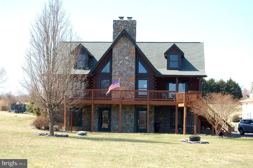 This beautifully maintained quintessential lake log cabin has four bedrooms, 3.5 bathrooms, and lake views from every room. The main level, with hardwood floors throughout, boasts a great room with vaulted ceilings, exposed beams, and a wood-burning fireplace, the primary bedroom with direct access to the front deck, a kitchen with all-new stainless appliances, and an adjacent dining area. Upstairs there are 2 additional bedrooms with full bath, and the basement has a 4th bedroom, full bath, and family room with a second wood-burning fireplace. Outside, the main level deck stretches across the entire house with covered porches on either side. Below this is a concrete patio perfect for grilling. Significant improvements have been made since 2021; new roof, new asphalt driveway, new appliances, new furnace and heat pump, new windows and sliding door, new front deck/railings, new whole house Generac generator, and the house has been recently washed and refinished. The home is situated on a large flat lot, just a short walk from the common area where you will find your own deeded slip (#14). Almost everything conveys, furniture, rugs, kitchenware, outdoor furnishings, bedding, and window treatments (see exclusions in MLS docs). This home is turnkey and ready for you to start vacationing 24/7!