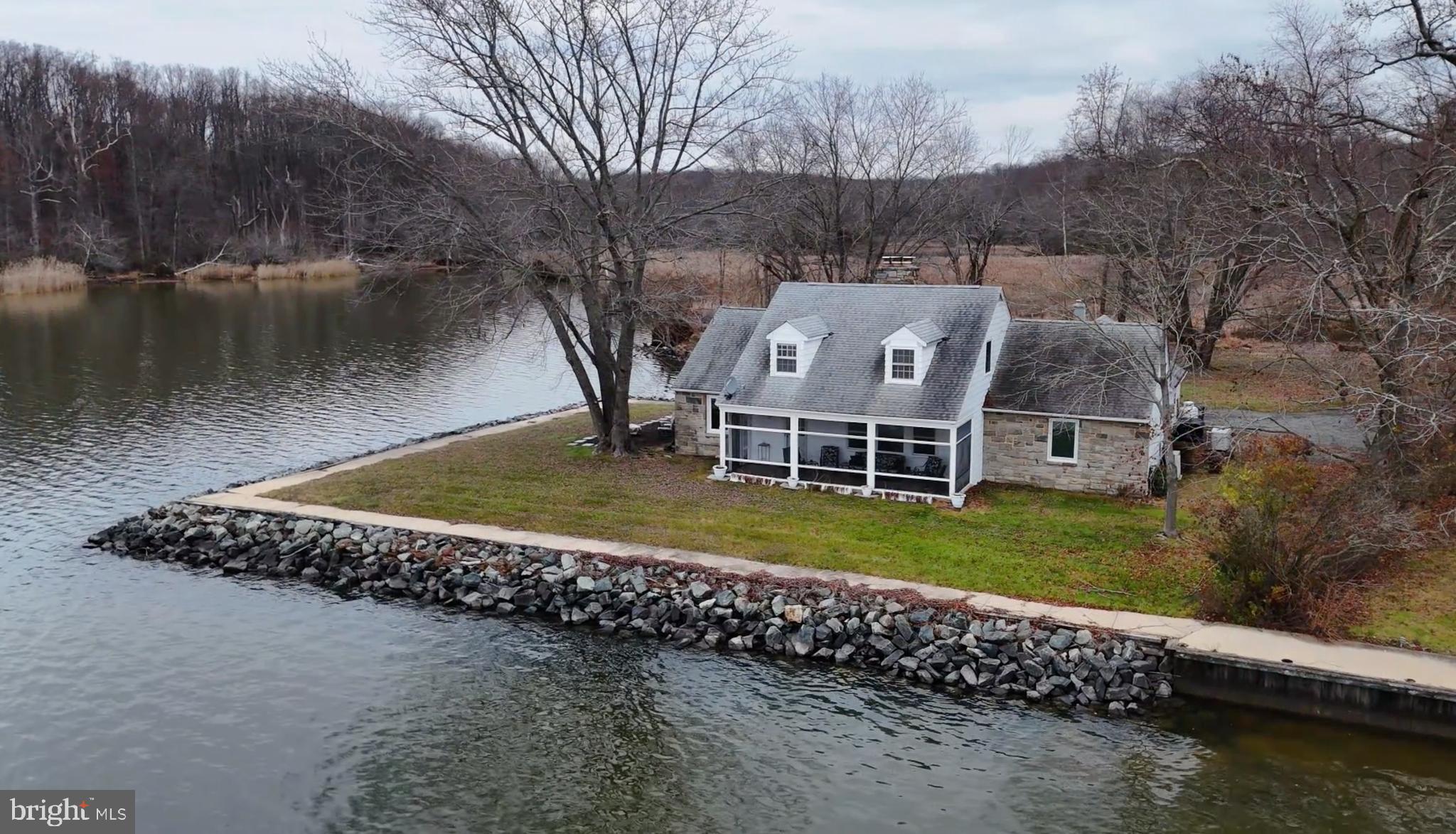 Presenting 71 Browns Manor Way, in North East, MD. This property is incredibly unique because it is not only situated directly on the Northeast River to view the boats by day and the most stunning sunsets by night, but it also borders the cove on the side to view a daily show of all the amazing wildlife. The back of the property, offers the marsh to go exploring by kayaks and paddle boards. Every morning you are greeted by the sunrise over the marsh. This private property is located on .72 acres and sets amongst only 11 properties made up of a quiet community aside of Sandy Cove. This Cape Cod's main floor offers a foyer, a full eat-in kitchen with oak cabinetry and quartz countertops, full bath, open concept expansive 27' x 13' living room and dining room with a wood burning fireplace with brick surround, an extensive den with a wall of windows capturing the water views which has another wood fireplace and encased by stone. Stepping out to the large waterfront screened-in porch where most time is spent, capturing many memories to come. The primary bedroom ensuite provides a vast amount of space 17' x 17', with a walk-in closet. The private bath has a walk-in shower. The 1st floor is complete with a laundry room and garage. The 2nd floor landing provides plenty of space for a coffee station or a drink and snack area, when all your guests fill your home! There are 3 spacious bedrooms with their own individual ductless mini split systems for perfect temperature control, 1 full bath and you'll also find another 2 very large bonus rooms! The main floor has central air and the heating system is oil. For added comfort level, there is a whole house automatic propane generator which will convey. In 2015 new vinyl soffits were added to the house. The roof is only 10 years old. The riprap installation to protect the integrity of the property was 45k. This property was on a "shared well", therefore as a courtesy, the seller just had a brand new well and well pump installed this week (so the new buyer won't need to incur the expense or go through the process of obtaining county permits, etc.) The seller currently pays $787 for flood insurance per year. Please refer to the details for room dimensions. Property will be available for showings effective December 27. Out of courtesy and respect for the neighbors, please DO NOT do any "drive-bys". You can secure your showing appointments now for the start of Dec. 27th and beyond.