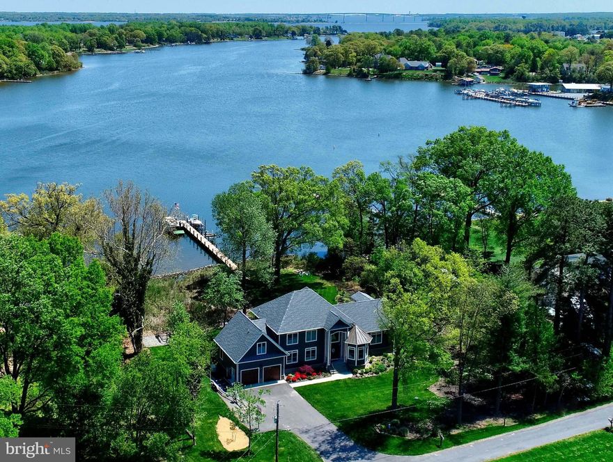Stunning, one-of-a-kind waterfront home custom built in 2018.  Located on the most sought-after creek along the southern Patuxent River, this home is just minutes from the Chesapeake Bay, Solomons Island, Broome’s Island and much, much more by boat.  The 120-foot pier has two boat lifts, two jet ski lifts, underwater fish lights, floating dock/swim-platform, swim ladder, electricity and fresh water, filet stand with rod holders, dock lights and a flagpole.  This area has the BEST crabbing from the dock in all of Maryland.  Property has rip/wrap living shoreline, to protect the property from erosion, and features a mature oyster reef for all the oysters you can eat.  There is an osprey nesting pole off the pier as well.   At the start of the pier is a kayak stand that can hold up to six kayaks, or a combination of kayaks, canoes, and small sunfish-style sailboats.  Small area in rear of house can store boat trailers if needed. A short walk up toward the house, allows you to enjoy s’mores and cocktails by the fire pit.  Relax in the six-person hot tub beside the house.  Rinse off in the outdoor shower after a dip in the river or hot tub!   This three-story house features five ensuite bedrooms, with full baths, and two half baths.  The main floor has a huge master suite with an oversized walk-in closet equipped with a large washer and dryer and a safe room.  The master suite features a sitting area with expansive windows, facing the water with a gorgeous eastern exposure, with an exit to the large, covered porch.  The master bathroom has a deep soaker tub, with large window, an oversized, two-person shower, his and her sinks. The vaulted ceilings in the living room provide amazing views of the water, while you relax in front of the gas fireplace, featuring floor to ceiling stone and custom built-in shelving on both sides.  There is a half-bath off of living room.  The open floorplan provides a view of the kitchen, featuring an oversized island with double sink, instant hot, dishwasher, and microwave.  Kitchen has full-size, side-by-side refrigerator and freezer, a double oven, gas cooktop, quartz countertops and a breakfast nook with built-in seating and storage, all overlooking the water.  From the kitchen, enter through the door to the covered, outdoor porch perfect for enjoying a cup of coffee in the morning to watch an absolutely spectacular sunrise (never disappoints).  Porch features outdoor fans, outdoor speakers and plenty of room for seating.  Beside the kitchen is a butler’s pantry with a wet bar and copious pantry space. Dining room features custom, built-in shelving and custom wainscoting.   The office features custom built-in shelving and desk space as well as custom wainscoting. The mud room, off the garage, features custom built-in with storage, coat hooks, and an additional desk space.  Beautiful stairs up to the third floor are custom made with a split staircase.  To the right, enter a large suite with a walk-in closet and a full bath. Amazing views with a built-in reading nook.  To the left, cross the catwalk to get to two additional ensuite bedrooms both equipped with full bathrooms and lots of closet space.  Additional playroom/bonus room has a ½ bath and another laundry room which will easily convert to a sixth bedroom and full bath if desired.   The lower level is set up as an in-law suite with its own private entrance and separate workshop/garage space, perfect for lawnmower/jetski storage and fishing gear!  The in-law suite has a sliding glass door to a covered patio area with hammocks and a hot tub overlooking the expansive waterfront.  Perfect area for a grill and possible future, outdoor kitchen (gas line already in place from the 1000-gallon underground tank).  In-law suite houses a full kitchen, with quartz countertops, fridge/freezer, electric range/oven, microwave, and a dry bar area with wine fridge.  Deadline to submit your offer May 28th by 1pm
