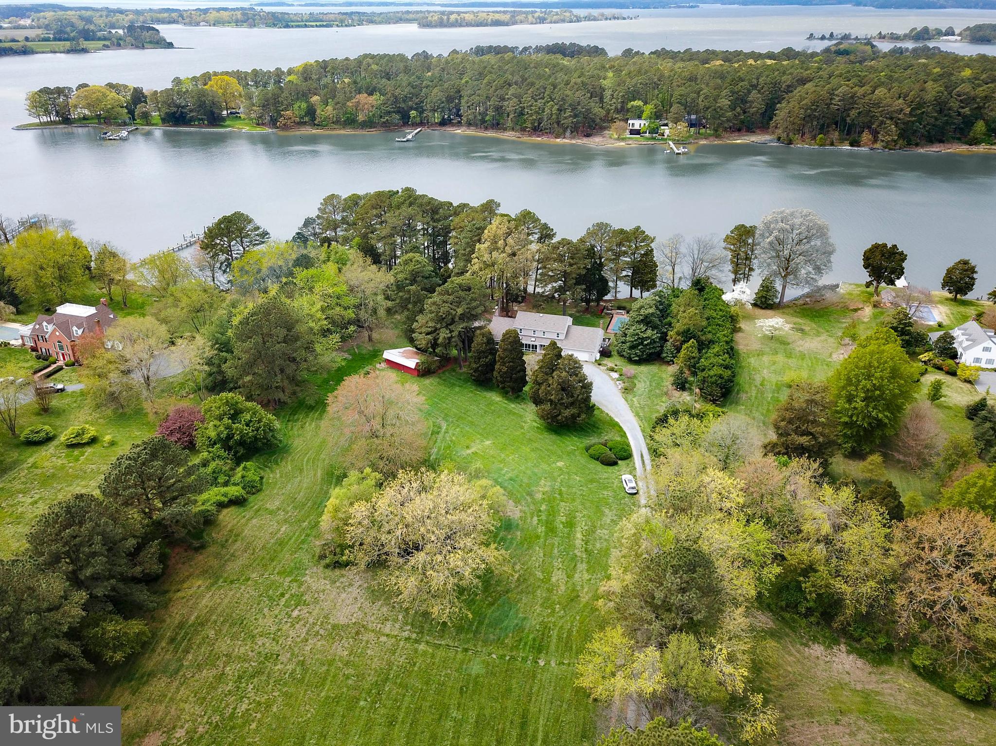 Waterfront in Royal Oak. This Colonial has everything on your wish list! Private setting, centrally located between Easton and St. Michaels, this home features 4 Bedrooms, Primary Bedroom on main level with huge walk-in closet and Bath with soaking tub and separate shower; 3 bedrooms, 2 full baths on second level with plenty of storage and an office. Large Family room with cathedral ceilings, brick fireplace, large kitchen with white cabinets, separate dining room, cozy den, huge sunroom with a wall of glass, green house porch, 2 car garage, generator, public sewer system. Property is 5+/- acres, mature landscaping, improved with an inground pool approx.. 40’ from the waters edge, boat launch area, sandy beach, small barn/shed, pier with 4.5’ MLW, boat lift. Expansive western view across Solitude Creek.