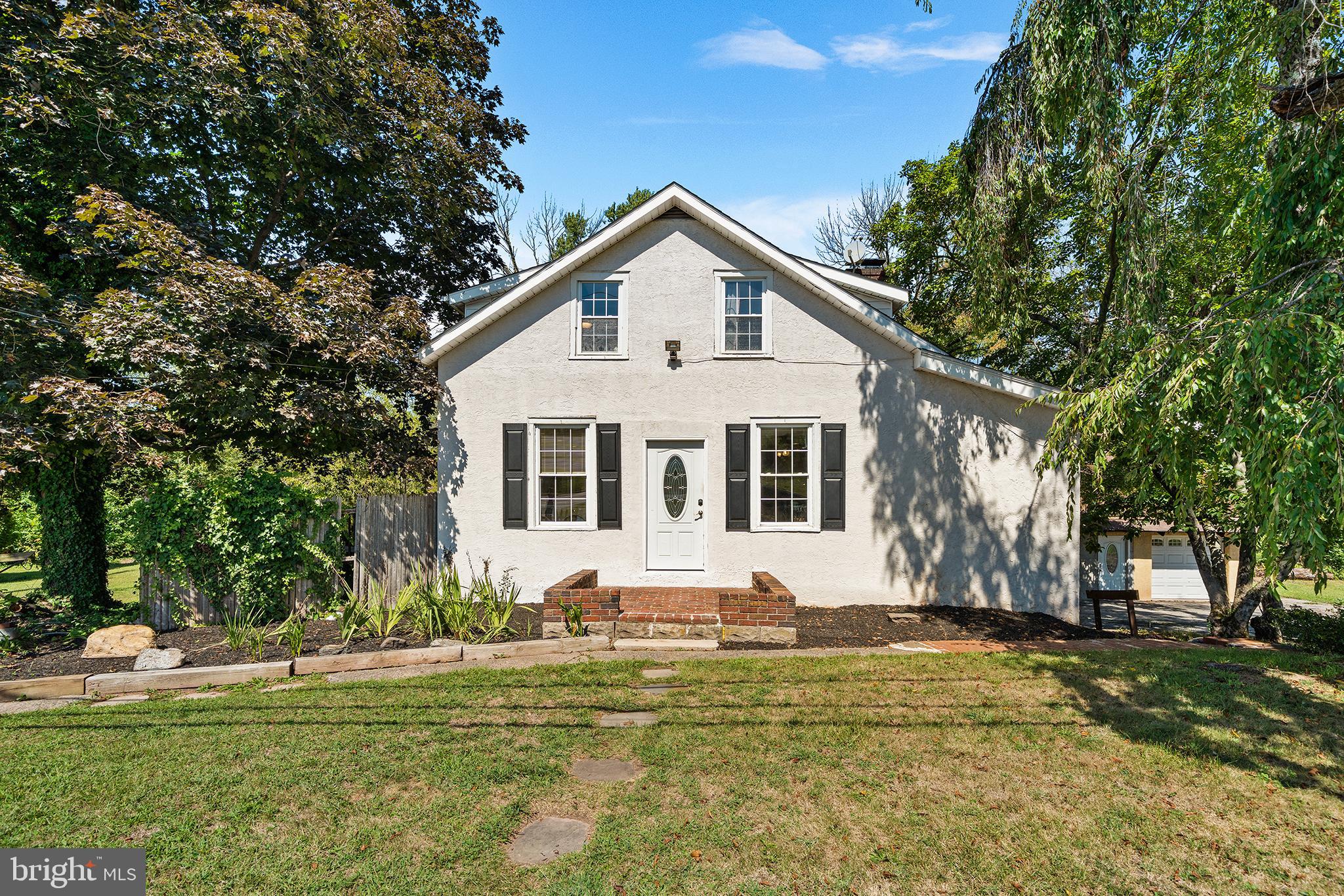 Cottage-Inspired Cape Cod Retreat with In-Law Suite on Nearly 2 Acres in Spring-Ford School District! Welcome to your own private sanctuary—this charming Cape Cod-style home offers the perfect balance of timeless character, modern updates, and flexible living options, all set on nearly 2 beautifully landscaped acres. Shielded from the road by mature trees and fencing, the property features peaceful gardens, a tranquil stream, and even a small pond—an oasis of nature just minutes from everyday conveniences. Inside, the main home offers 3 bedrooms and 1.5 bathrooms, blending original charm with thoughtful renovations. The kitchen was completely redone in 2011 with updated countertops, electric cooking, all new appliances, drywall, insulation, and flooring. The living room was reconfigured in 2014 to add a cozy den and first-floor laundry, while the original side porch was finished in 2024 into a bright home office. Upstairs, you’ll find three comfortable bedrooms, including a refreshed primary suite (2019) with custom closet organizers, and a full bath renovated in 2015. The home has seen extensive system upgrades for peace of mind: new roof (2019), 200-amp electric service, updated plumbing and electrical, new well pump and system (2019), electric hot water heater (2019), and a new HVAC system (2022). A full walk-out basement provides ample storage and easy access to the lower driveway. Step outside to a spacious back deck overlooking the gardens and natural landscape—perfect for entertaining, dining, or quiet evenings surrounded by wildlife. Adding incredible versatility, a large second building includes 1.5 baths, a lower-level workshop/garage space and a finished family/game room. Above, a sun-filled apartment with cathedral ceilings, kitchen, and full bath offers endless options—whether as an in-law or au pair suite, home office or studio, guest quarters, or rental income opportunity. Previously used as an Airbnb and art studio, it has generated up to $30K annually. The property is also subdividable, making it a strong investment opportunity in addition to being a truly unique retreat. Recent improvements across both buildings include new roofs, heating/cooling systems, water heater, and more—yet there’s still room for you to add your own touches. Whether you’re searching for multigenerational living, a private oasis, or a home with strong income potential, this rare gem in the award-winning Spring-Ford School District has it all.