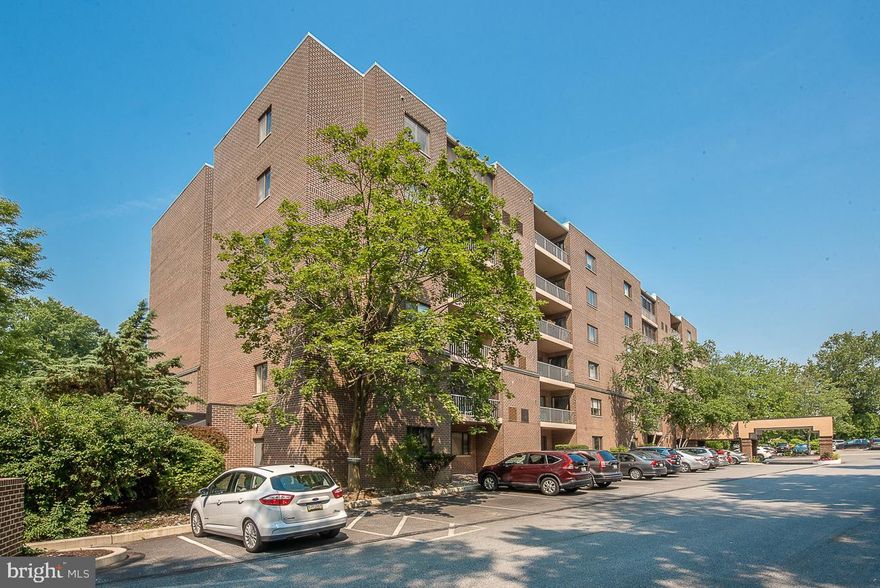 Meticulously maintained first floor unit with sliders out to a rear ground floor patio overlooking the open space with trees and stream.  Beautiful white kitchen with granite countertops and plenty of cabinets for storage.  An open and spacious living room and dining room making entertaining easy and gracious.   Main bedroom with deep walk-in closet and main bath with stall shower.  Second bedroom and hall bath.   Storage locker included too!  The Condo fee includes: Pool usage, water, common area maintenance, trash, exterior building maintenance, landscaping and snow removal.  Beautiful lobby, library and social room on site.  Property has management secured access and doorman everyday from 5 PM to 12 AM.  A coveted location within walking distance to Wynnewood train station, Whole Foods, Wynnewood Shopping Center, Giant Foods, CVS and more.  Enjoy easy living in a park-like setting.