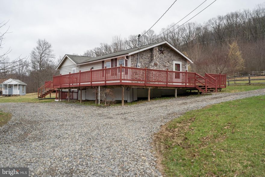 Farmette on the mountain, 10 acres partially fence and ready for your critters.  Main house with 2 bedrooms,  spacious kitchen area open floor plan, fireplace and wood stove, huge window wall to take in all the scenery, garden bath. From the large deck you'll see fruit trees and northwest view. Separate studio structure has many possibilities and ready for completion. Barn and several outbuildings. Cacapon River access for outdoor adventure.