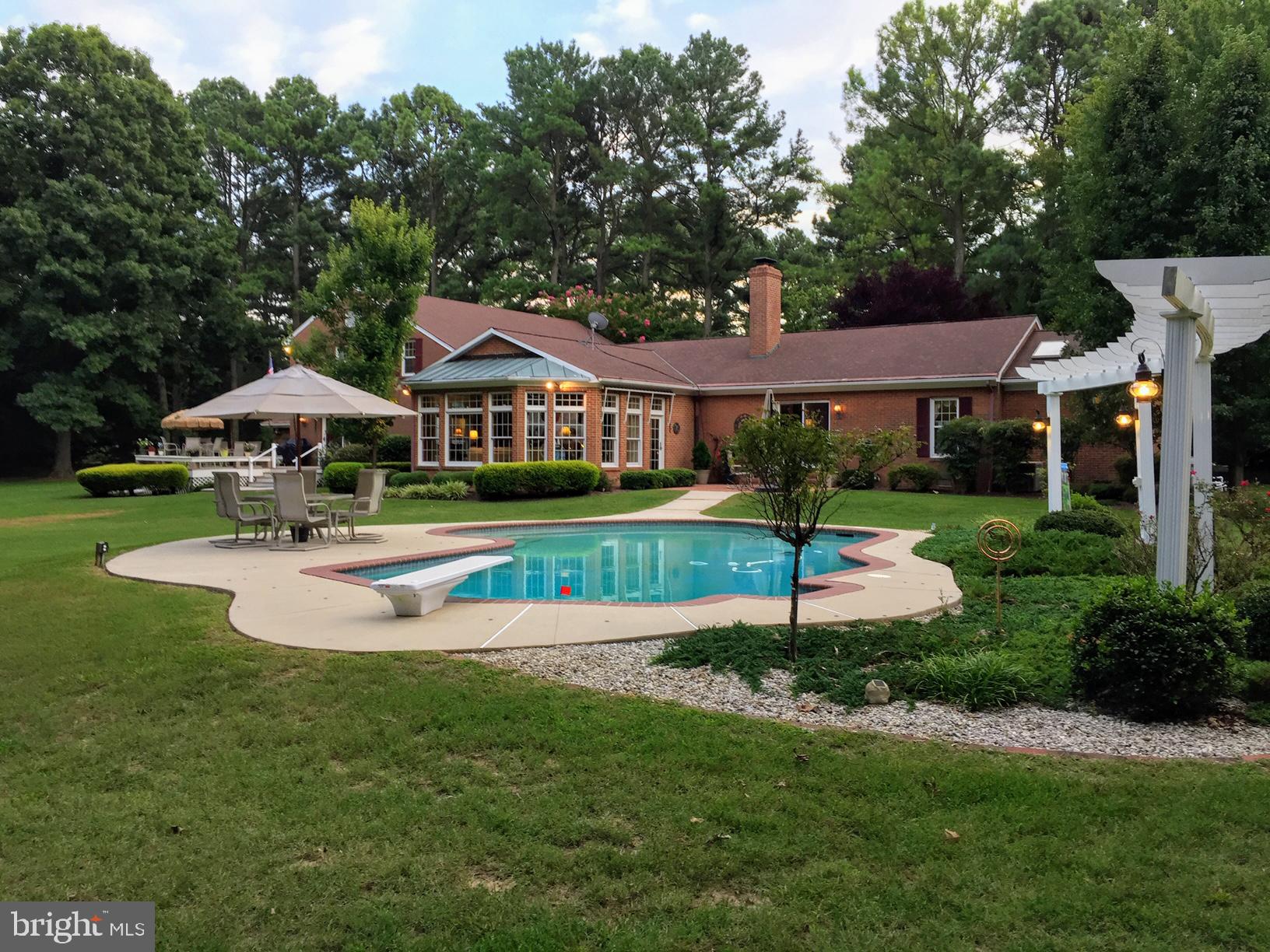 "One Particular Harbor"- Fabulous 5000 + sf brick waterfront home with waterside pool in desirable Oxford Road Corridor in Waverly. Situated on 2 + acres in park like private setting on Platers Cove off of the Tred Avon River, this contemporary mostly one level home boasts 4 + bedrooms & well defined living spaces including large River room with panoramic water views, formal living room (wood burning fireplace) and formal dining room. Spacious kitchen with granite, high end appliances, pantry and tons of cabinets and family room. First floor primary bedroom suite with wood burning fireplace and luxurious primary bathroom. Additional first floor bedroom/library with full bath. 3 bedrooms up with full bath and study. Hardwood floors through out. Septic approved for 4 bedroom. Outdoor features include patio, large deck, oversized deep gunite pool with 9'. Property has 4 + MLW, 480' shoreline with rip rap and protected harbor bulkhead slip, 10K boatlift. Attached 2 car garage and workshop.
