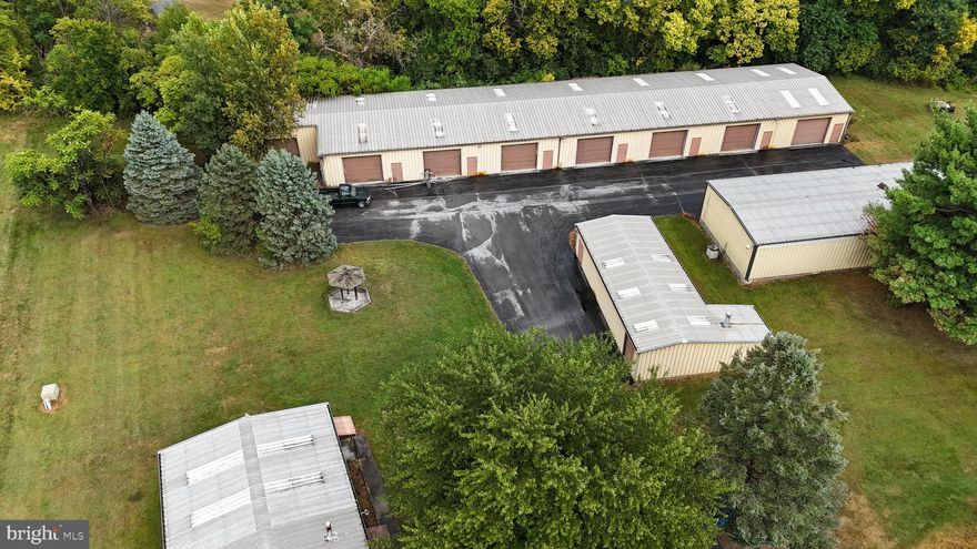 This commercial property is being offered as-is and is ideally situated on 3 acres along
Hopewell Road in Hagerstown, Maryland. It is bordered on both sides by active commercial
properties, offering high visibility and excellent access to key transportation routes.  The property features four metal-constructed buildings on site, along with ample parking.   One large central structure with an open floor plan, office, and a bathroom.  Two buildings are dedicated to a paint booth and a woodshop, both with some open space and storage.   The fourth building consists of garage bays and storage unit facilities.  Total Estimated Usable Space (Including Bays):  14,944 square feet.. The property is in overall good condition.
