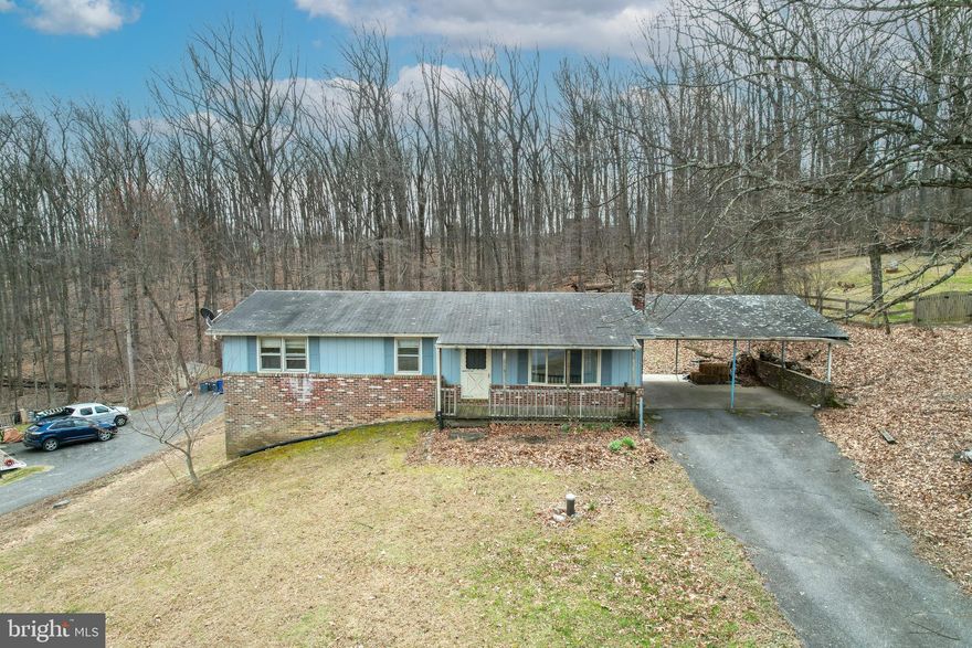 This rancher has the two things you can’t change... Location and great bones.  On the market active for showings now and ready for its next owner to bring it back to life. Sitting on just over a half‑acre and backing to trees, this 3‑bed, 2‑bath home begs for full renovation inside and out.  The main level features wood flooring in the dining room, hallway, and bedrooms. The full bath on this level was updated approximately 10–12 years ago. The lower level expands your living space with a large rec room option featuring a hearth for a wood stove, a second bath, and additional flex space you can tailor to your needs whether it be a home office, workshop, storage, or hobby room.  A generous lot, mature trees, and a quiet setting make this a great opportunity for someone ready to transform a well‑located property into something special in the South Carroll area.