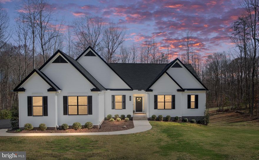 Stunning Atlantic Builders Bridgewater II model built in 2021, offering a modern farmhouse feel with main-level living and a spacious, open floor plan. This home features an inviting vaulted-ceiling living room, a gourmet kitchen, and a sunroom addition that fills the space with natural light. The large entry foyer with gleaming luxury plank flooring extends through the dining room, living room, kitchen, and sunroom. The split-bedroom floor plan provides privacy, with the primary suite featuring a luxurious ensuite bathroom and a walk-in closet on one side, while two additional bedrooms share a full bath on the other. A flex room serves as an office or optional 4th bedroom, plus a formal dining room and a convenient half bath complete the main level. The finished lower level offers a massive rec room with professionally finished concrete flooring for an industrial-modern look, a large wet bar with an island, and custom floating shelving. There is additional finished space separate from the rec room that is currently used as a play area, but has endless possibilities. A bedroom bump-out makes for a perfect 5th bedroom or guest suite, plus two unfinished rooms currently used as a gym and studio, along with a large storage/utility area. Step outside to the newly added large stamped concrete patio with custom pergola, overlooking the spacious private backyard with a playground and nature trails already in place. Located in a cul-de-sac on nearly 5 acres in desirable Stafford Estates, this home offers privacy while still remaining close to shopping, schools, and restaurants. Some Upgrades & Features: Black upgraded exterior windows, 9-ft ceilings in the lower level, Whole-home water filtration system, Stylish electric fireplace,  New modern faucets & light fixtures throughout.  This home is a rare find with too many upgrades to list—schedule your showing today!