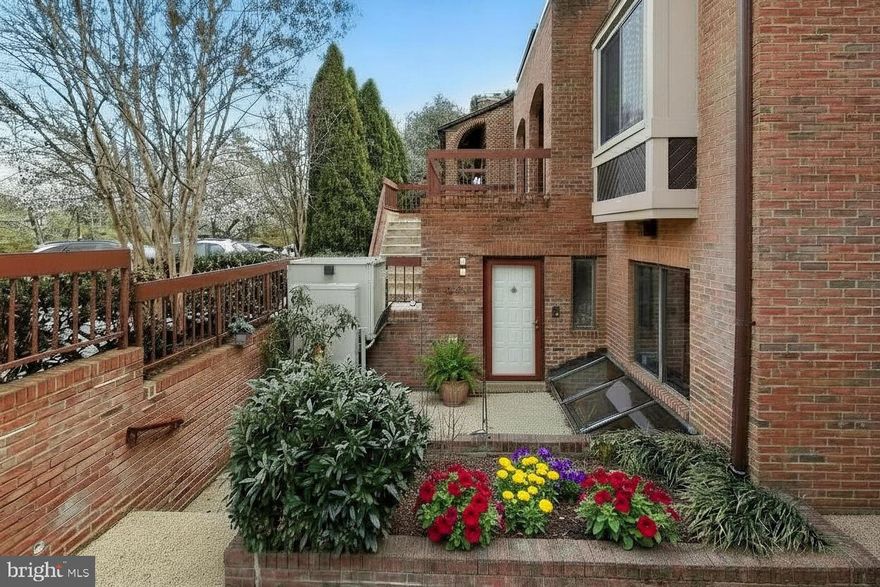 Welcome to this two-level, two-bedroom, two-and-one-half-bath condominium townhome in the Walter Johnson School District. This is truly a distinctive property with bold colors and playful décor — it feels like an artist’s retreat! Extensively updated and meticulously maintained, this vibrant residence offers an inviting living room with fireplace and sliding doors; an open dining room with a decorative ledge, basket-woven metal accent wall, and statement lighting; an impressive modern gourmet kitchen; a combined laundry and storage area; and a powder room on the main level. The large, thoughtfully designed chef’s kitchen provides an exceptional amount of granite counter space, including a breakfast bar, granite backsplash, pantry, atrium window, and abundant natural light highlighted by an exposed brick wall.
The entry level features two en-suite bedrooms and two renovated full bathrooms, along with excellent closet space and a foyer accented by fun checkered floor tile. A chairlift enhances accessibility between levels, offering ease of movement and supporting comfortable aging in place. The spacious primary suite serves as a private sanctuary, complete with a balcony, walk-in closet, vanity area, and a spa-inspired bathroom. The magazine-worthy primary bath includes a double trough sink, built-in dresser, and an oversized glass-enclosed shower with stone flooring and black granite walls.
Enjoy dining, entertaining, or relaxing outdoors on the balcony or the rare, enclosed private patio (one of only two in the community)—offering a secluded setting ideal for relaxing, entertaining, and gardening. The unit also benefits from access to an exterior elevator, providing added convenience and accessibility. Convenient to everything Bethesda has to offer, including the Bethesda Trolley Trail, NIH, Walter Reed National Military Medical Center, and the Grosvenor Metro. Easy access to Wildwood Shopping Center, popular dining destinations, and major commuter routes including I-495, I-270, Old Georgetown Road, and Rockville Pike.