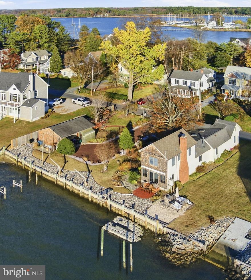 Welcome to Silly Manor, a Chesapeake Bay-front property with an abundance of coastal charm and panoramic views. This home is perfectly situated on the coveted Lawton Avenue, one of Kent County's most sought-after neighborhoods.  Enjoy stunning sunsets all year-round and direct access to the dynamic waters of the Chesapeake Bay. 
The open living and dining space offer spectacular views of the Chesapeake. The kitchen opens up to the patio and garden, and has a spacious island for entertaining. The home was designed with a first-floor primary suite, offering convenient (and hard-to-find) one-floor living.  There are two additional bedrooms and a full bath on the second floor.  Watch the boats glide in and out of Swan Creek all day long, or enjoy the cozy fireplace during the colder months, with the Bay sparkling just outside.  
This is one of the larger parcels on Lawton, and it boasts a detached, oversized one-car garage, along with a separate workshop.  The hardscape patio and stone walkways are perfect for al fresco dining or simply soaking in the surrounding beauty. The home feels very private, yet is located just minutes from many marinas, restaurants, shops and the Rock Hall Beach. This is the perfect weekend retreat or full-time home!